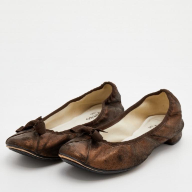 Prepárate para una comodidad constante cuando camines con estas bailarinas de Repetto. Fabricados en ante bronce metalizado, llevan puntera cubierta, lacitos y tacón bajo.