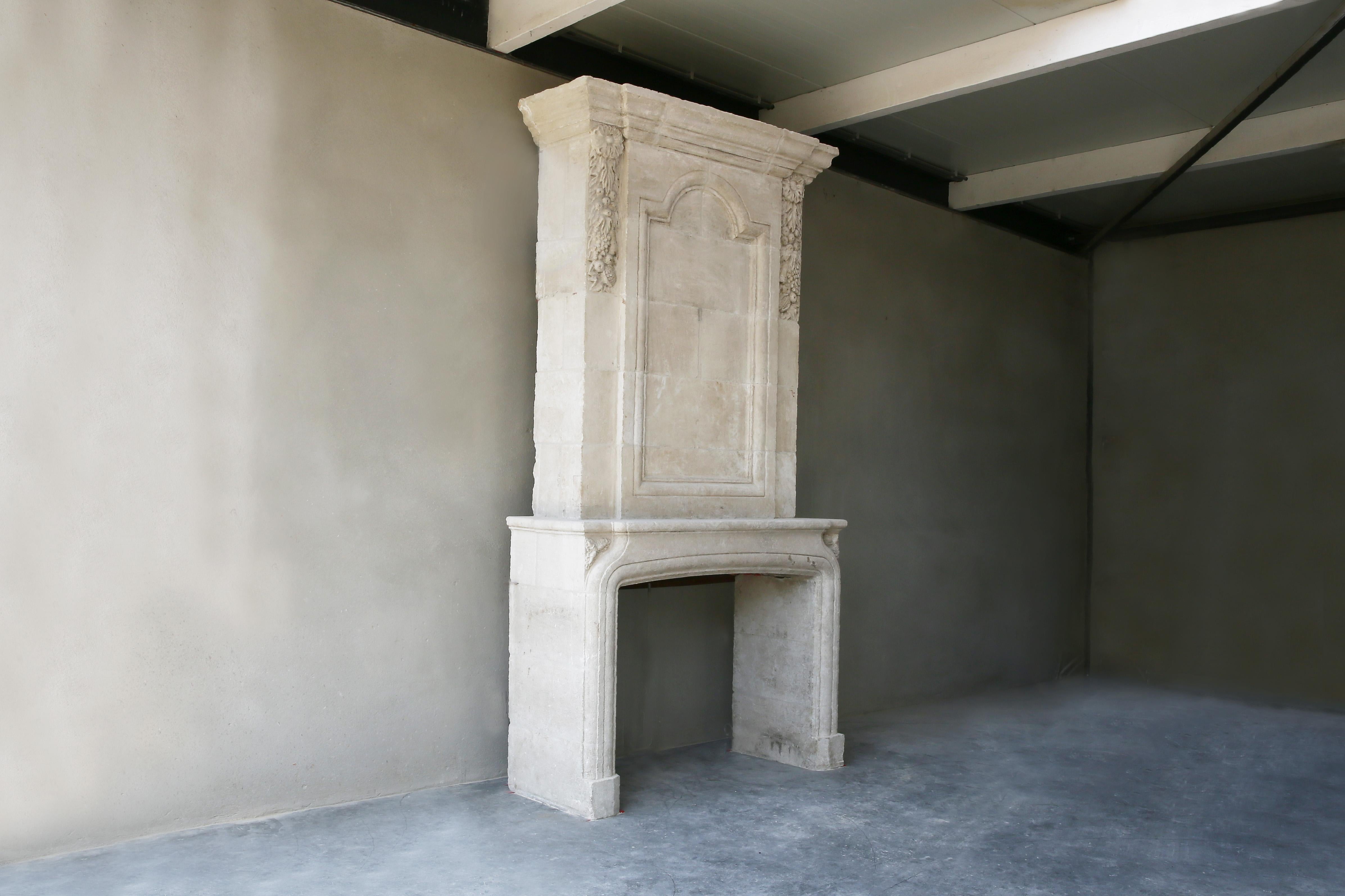 Nice replica fireplace made of French limestone including trumeau. The fireplace is made of French limestone and is made in the style of Louis XIII. There has been a small break in the front section, but it has been restored so well that you can no