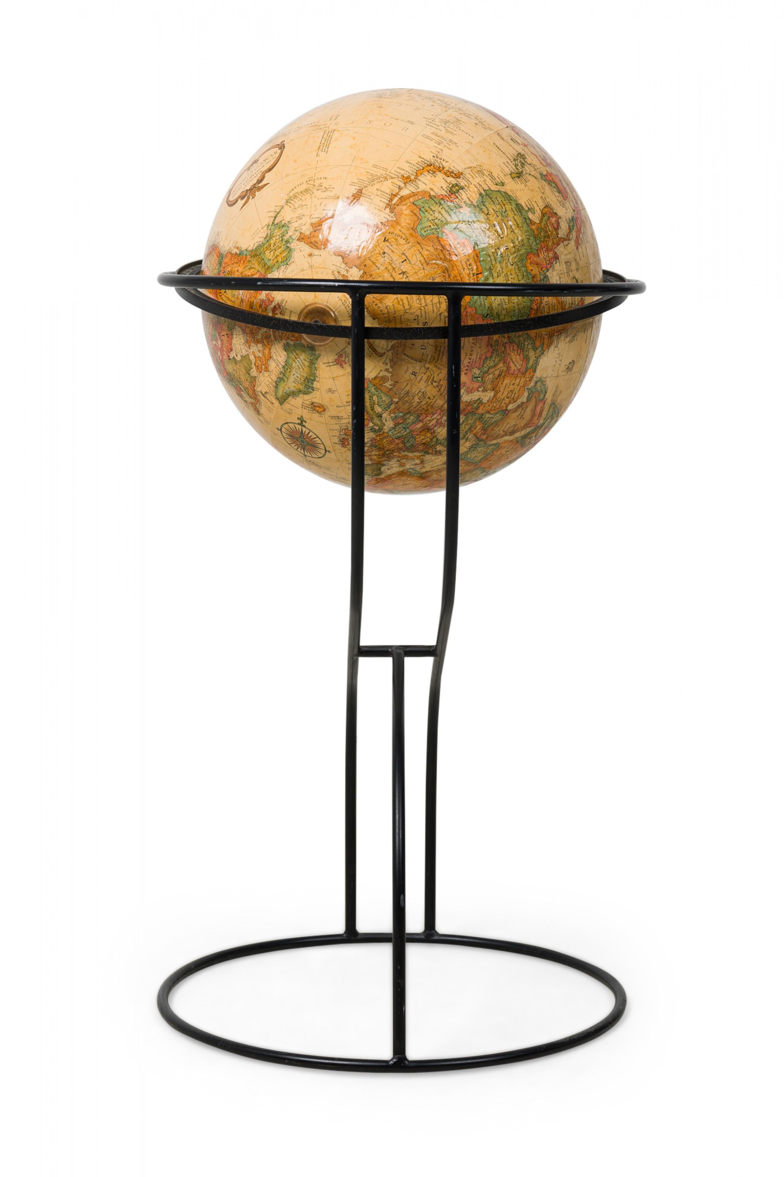 Vintage American Modern globe of the world resting on a curved cantilevered black metal stand (REPLOGLE).