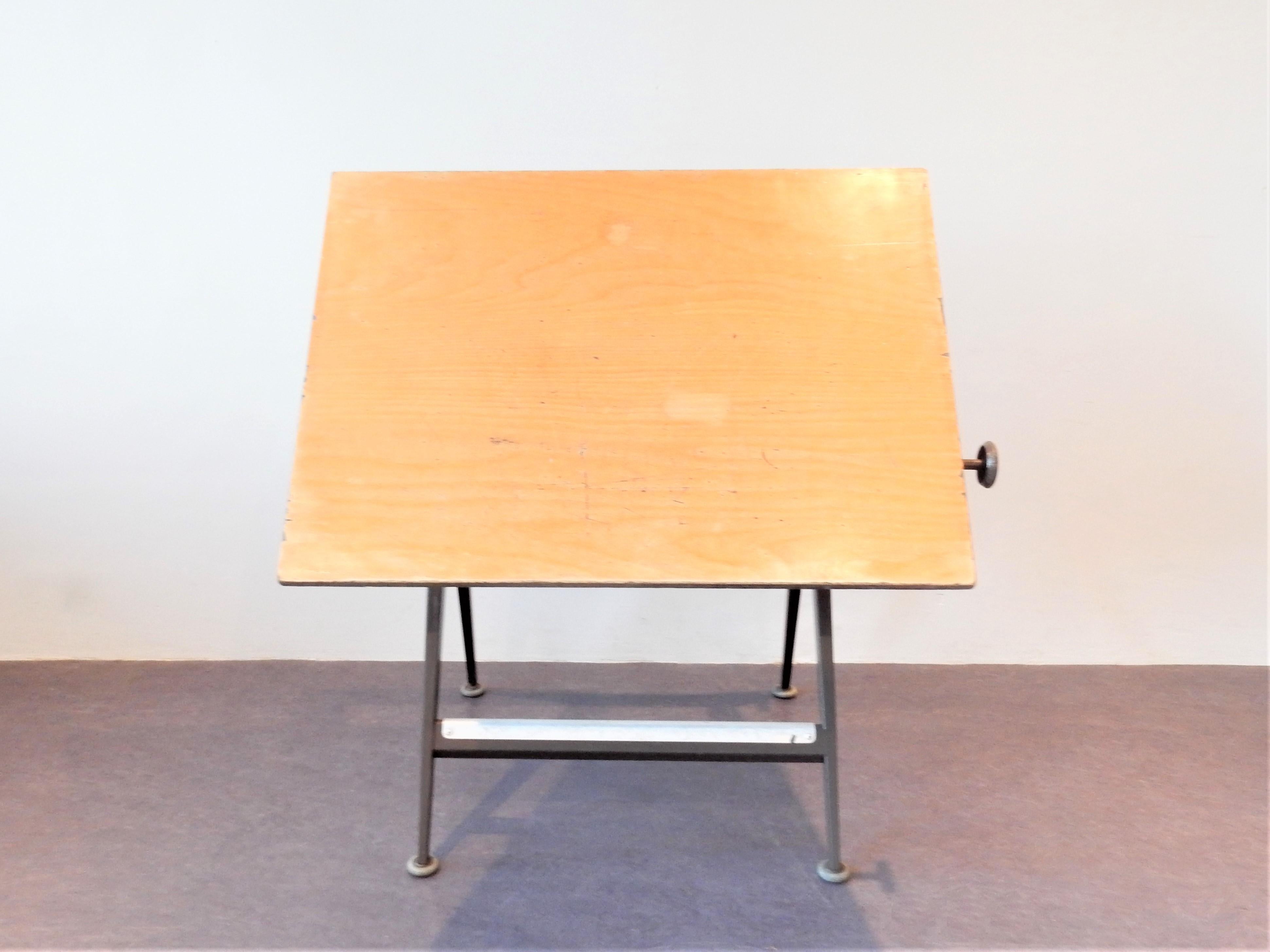 This 'Reply' drafting table was designed by Friso Kramer and Wim Rietveld for Ahrend de Cirkel in the 1950s. It has a brown lacquered steel frame and a ply wooden top that is adjustable from vertical to horizontal position by 2 rotary knobs. We have