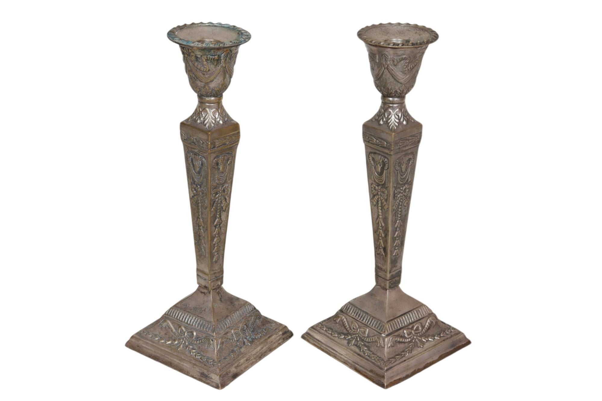 Coppia di portacandele in ottone repousse e silverplate. Decorato con dettagli floreali, drappeggi, nastri e ghirlande. Realizzato da/per Castilian Imports. Dimensioni per portacandele.