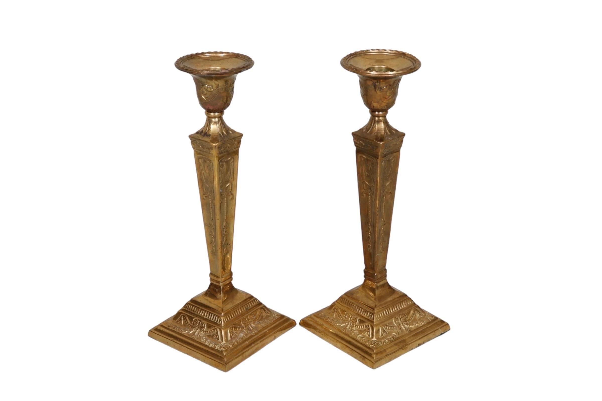 Coppia di portacandele a cono in ottone repousse. Decorato con dettagli floreali, drappeggi, nastri e ghirlande. Dimensioni per candeliere.