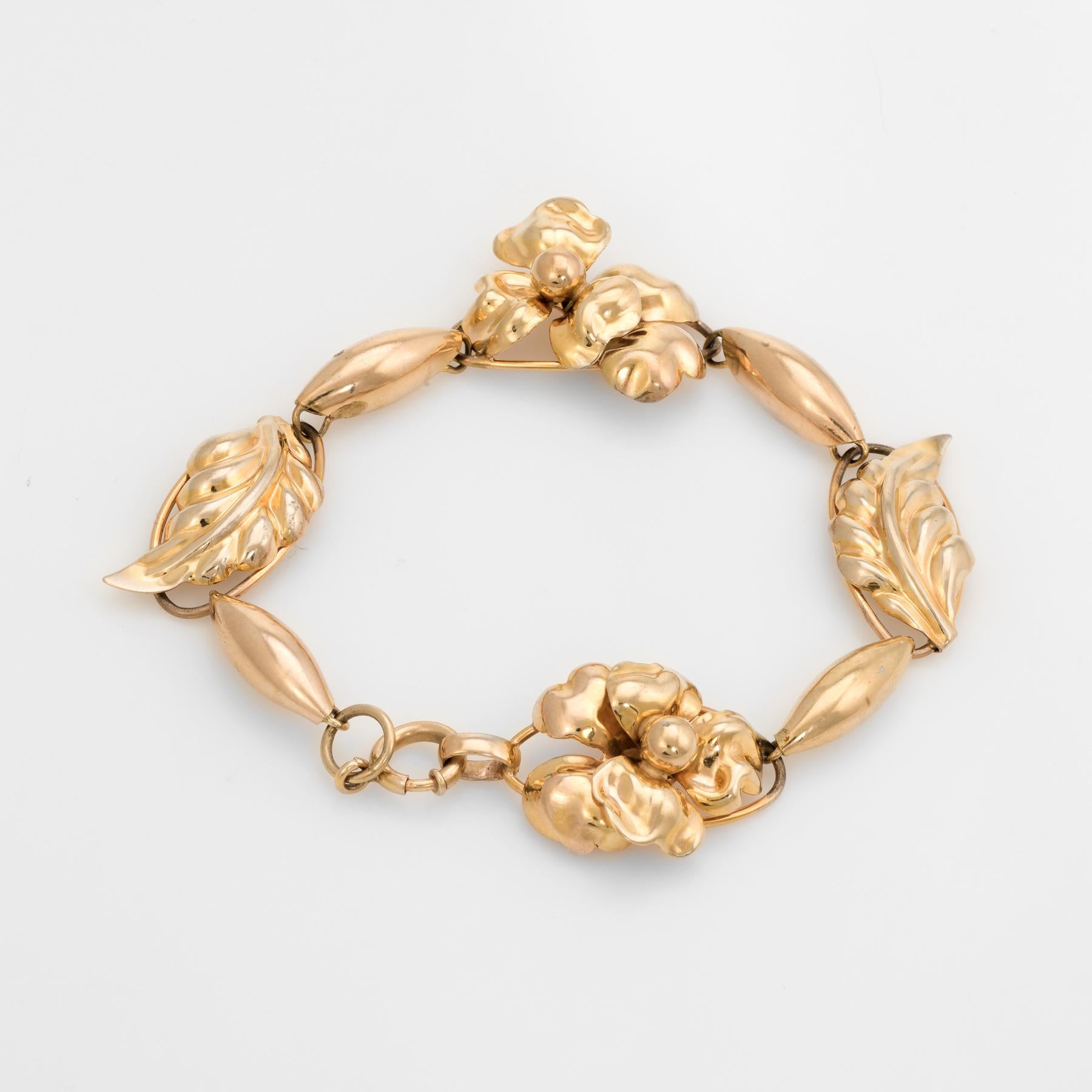 Elegant vintage bracelet (circa 1950s to 1960s), crafted in 10k yellow gold. 

The bracelet features an alternating flower and leaf pattern. Repousse is a metalworking technique in which a malleable metal is ornamented or shaped by hammering from