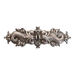 Boucle de ceinture Repouss en argent sterling représentant des dauphins baroques, par William Kerr, vers 1890