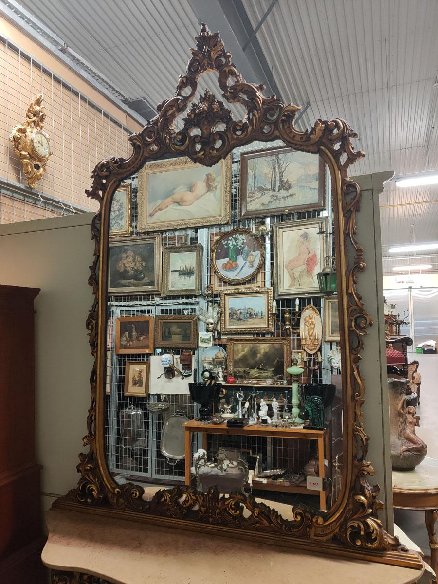 A stately and representative, free-standing console with a tall top-mounted mirror, with the rare motif of the Basket of Plenty in the top of the mirror.
Very rich carvings (numerous floral elements, flowers, etc.) in solid wood. Impressive,