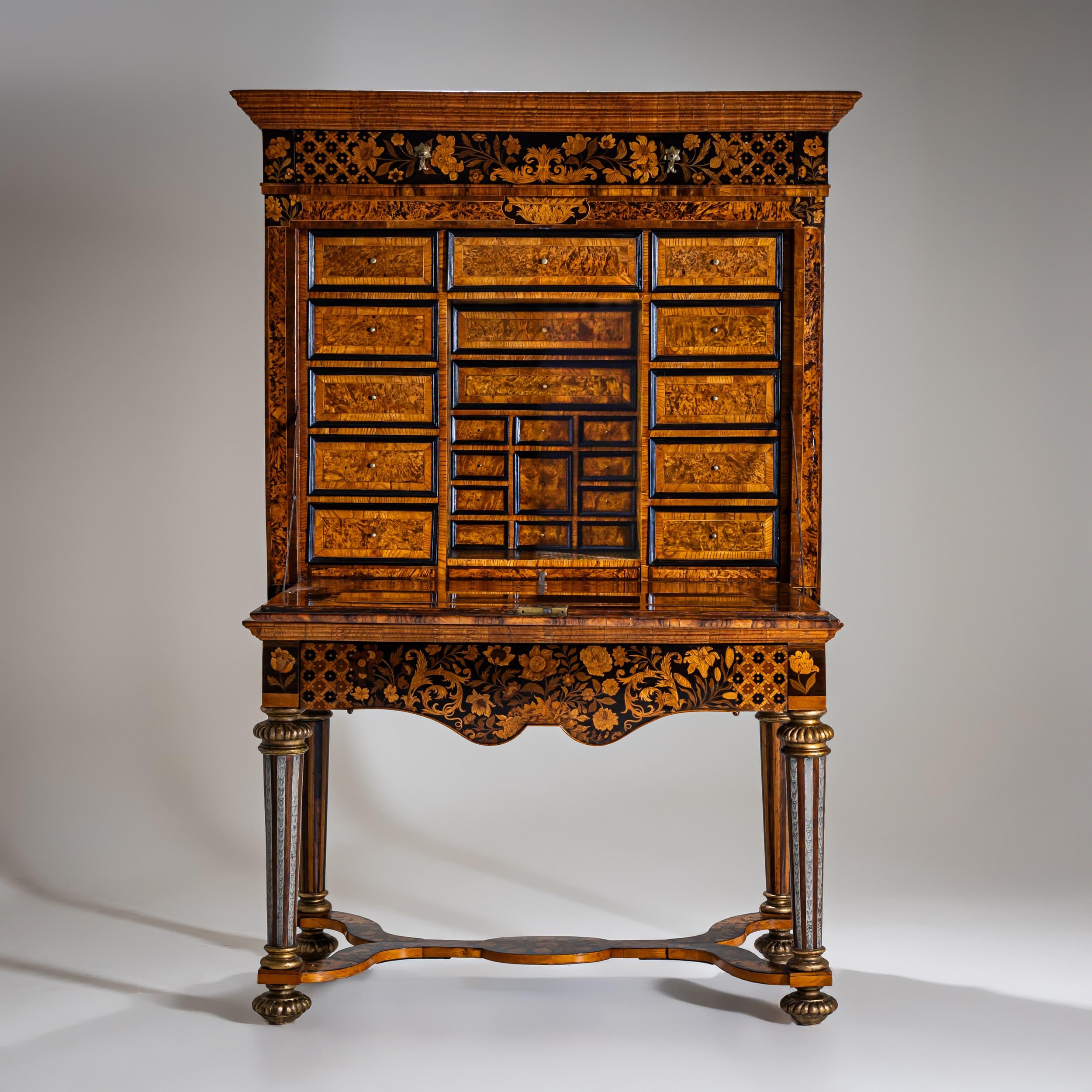 Representative secretary with a drop-front writing surface, richly inlaid with various fine woods, set on a tall stand adorned with engraved pewter bands, in the style of Thomas Pistor, London circa 1690. The interior was fundamentally altered in