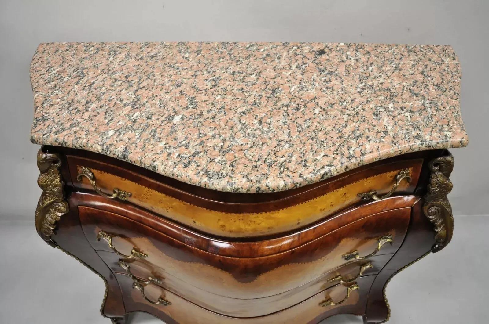 Riproduzione di un comò francese in stile Luigi XV con piano in marmo rosa. L'articolo presenta un piano in marmo rosa a forma di bombe, bronzo ormolu con teste di ariete, 4 cassetti, intarsi, grande stile e forma. Circa alla fine del XX secolo.
