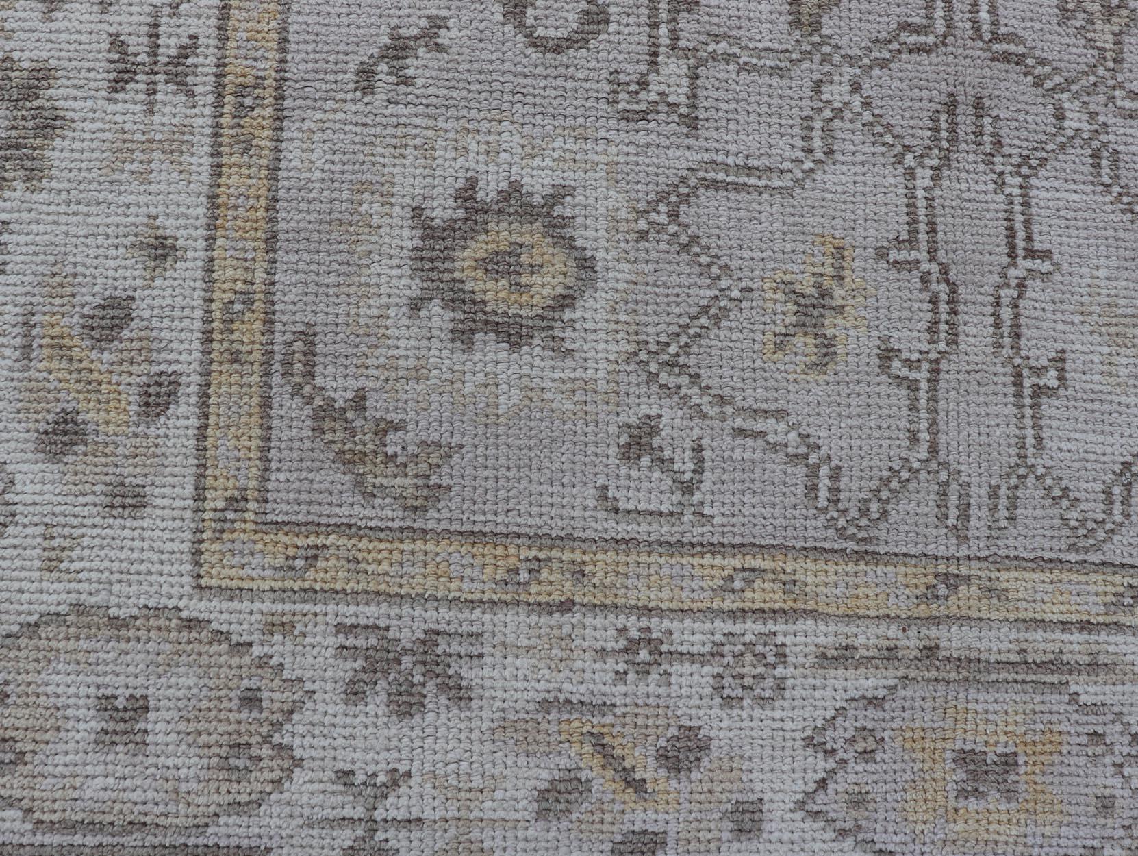 Laine Reproduction d'un tapis turc Oushak avec un motif floral stylisé dans les tons de la terre en vente