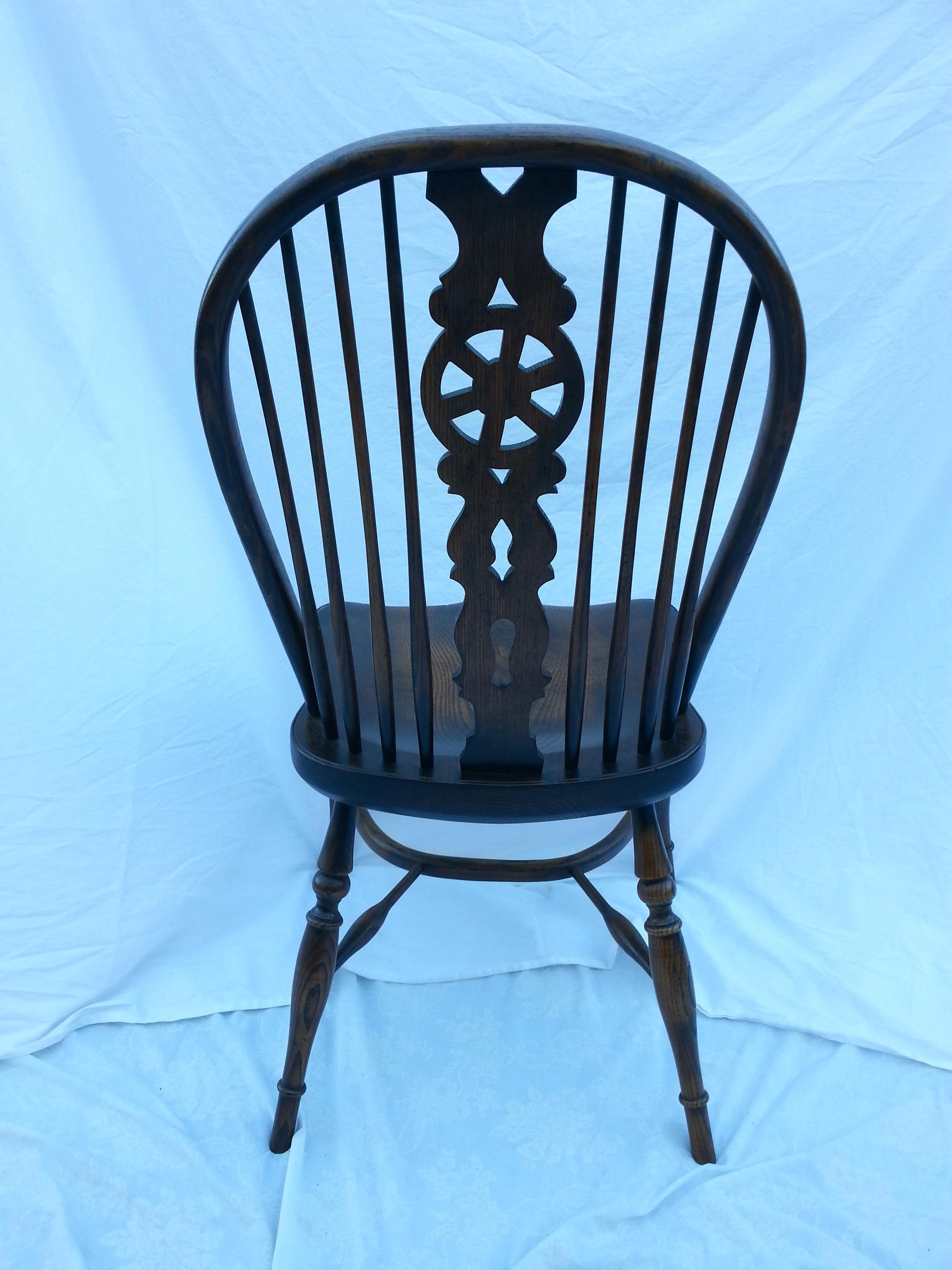 Reproduction wheel back dark stain armless chair.