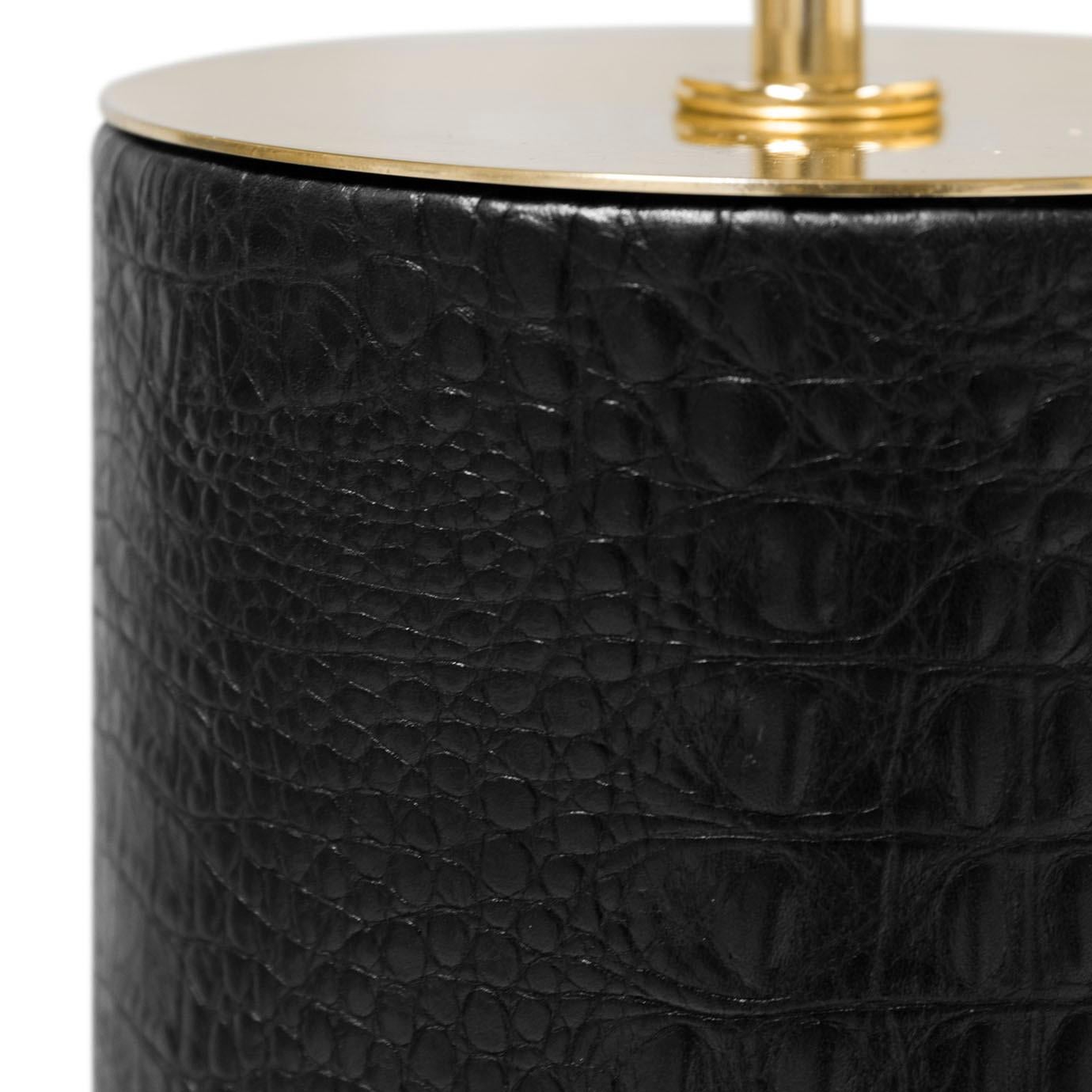 Take a walk on the wild side with the exotic design of the Reptilian Table Lamp. Lavish and wild, the lamp's cylindrical body is opulently wrapped in sumptuous leather while two seductively silent, hand-carved crocodiles curve around the marble