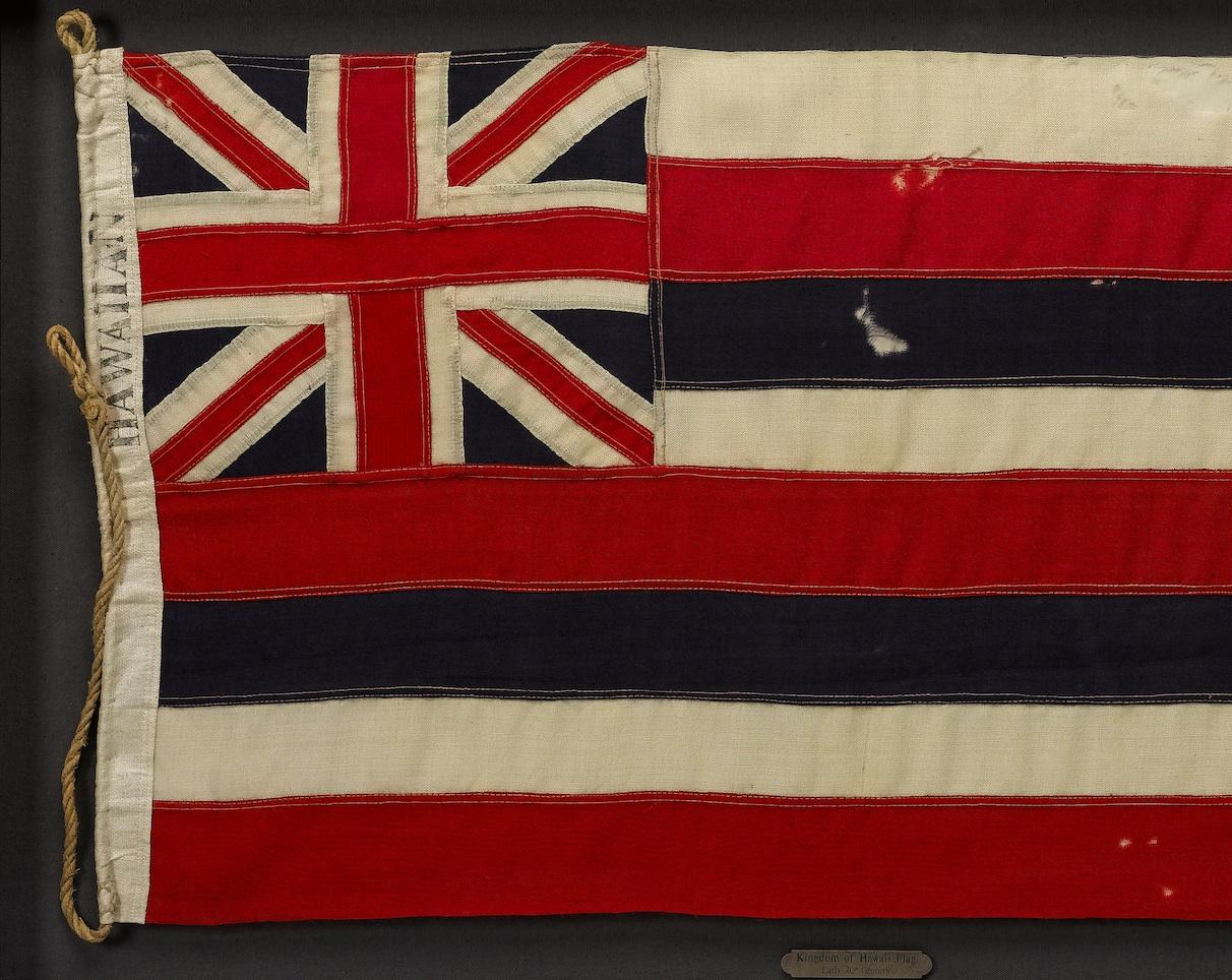 This is a vintage Republic of Hawaii Naval Stern Flag, published from 1894-1898. The canton of this flag of Hawaii contains the Union Jack Flag of the United Kingdom, prominent over the top quarter, closest to the flag mast. The Union Jack flag is a