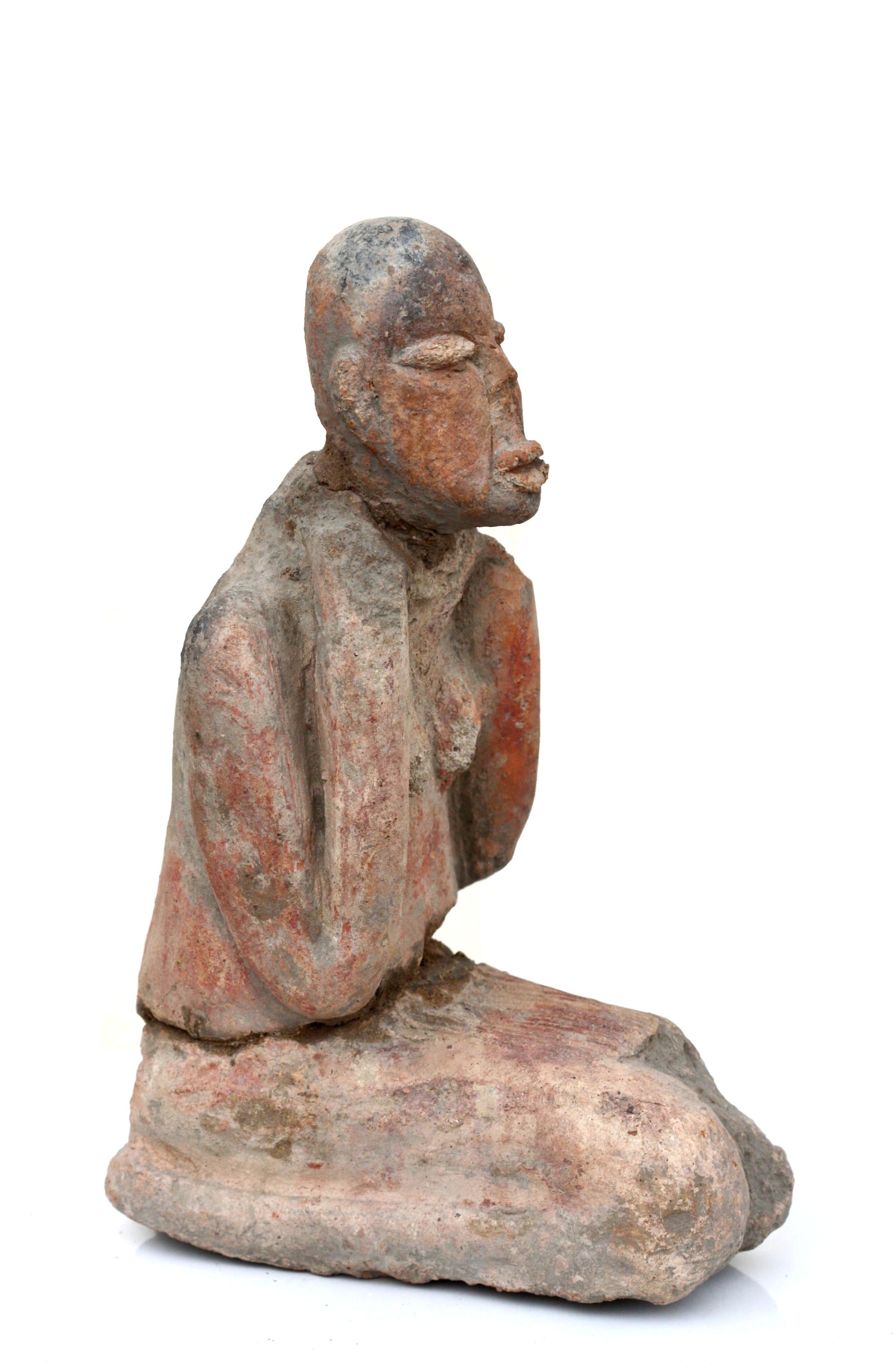 Republic of Mali terracotta figure of a female ancestral figure.
kneeling with her feet under her, arms to her shoulder,
circa AD 1100 - 1400 
Measures: Height 9 1/2 in. 24.1 cm.
Width 6 1/4 in. 15.8 cm.