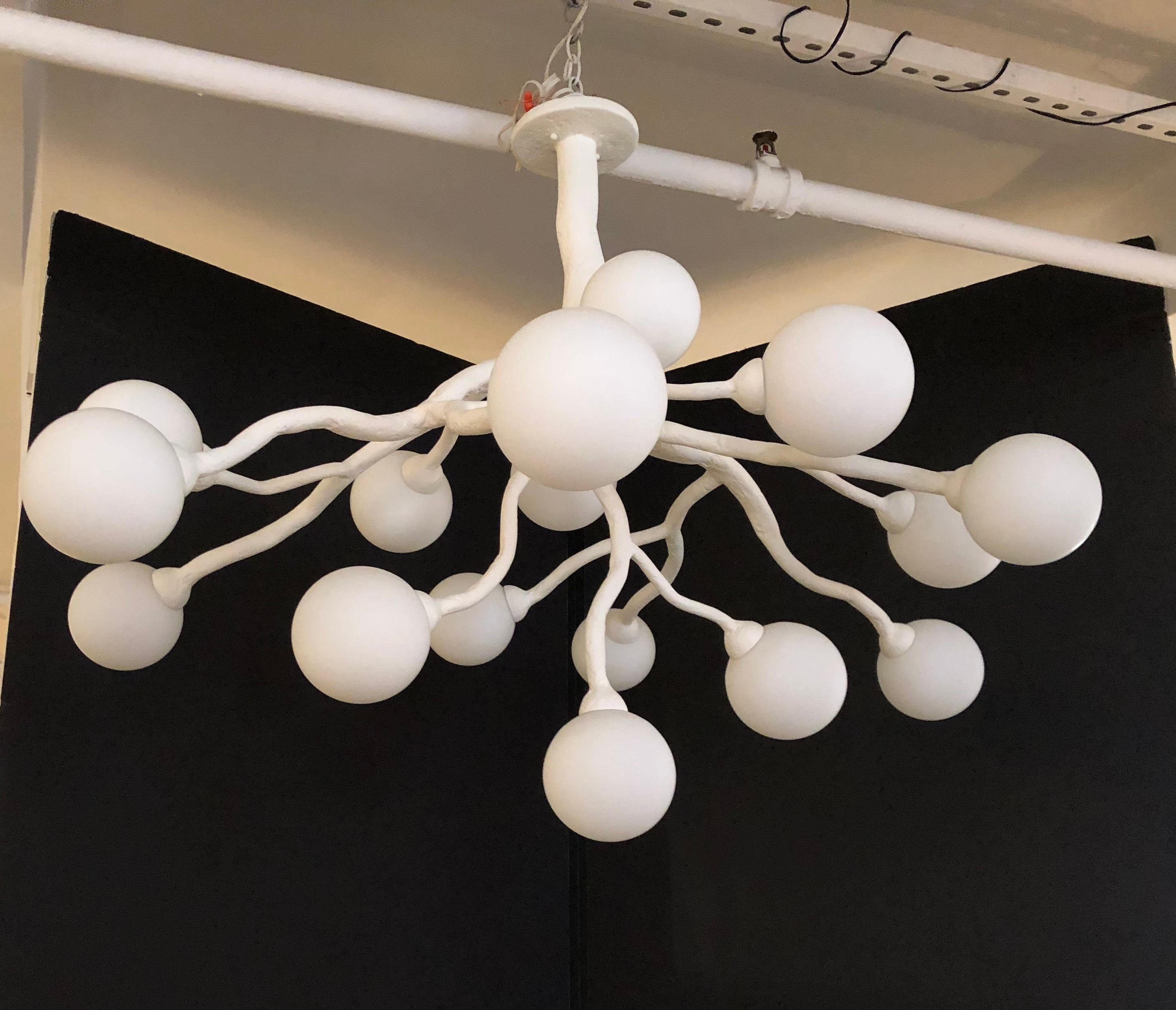 This unique chandelier has a plaster of Paris finish on it organic design frame. The light has 16 opaline glass diffusers. Light uses 16 candelabra base bulbs. Max wattage 40 each socket. This piece is created to order and we can customize the
