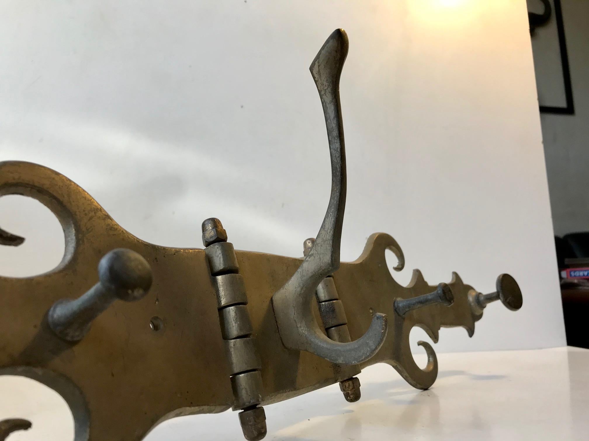 Unusual coat rack in solid patinated brass. Fashioned out of an old hand forged gate or large door bracket. Probably from a church or castle. We have been told that it was assembled sometime in the 1950s and has hung at an estate until recently.