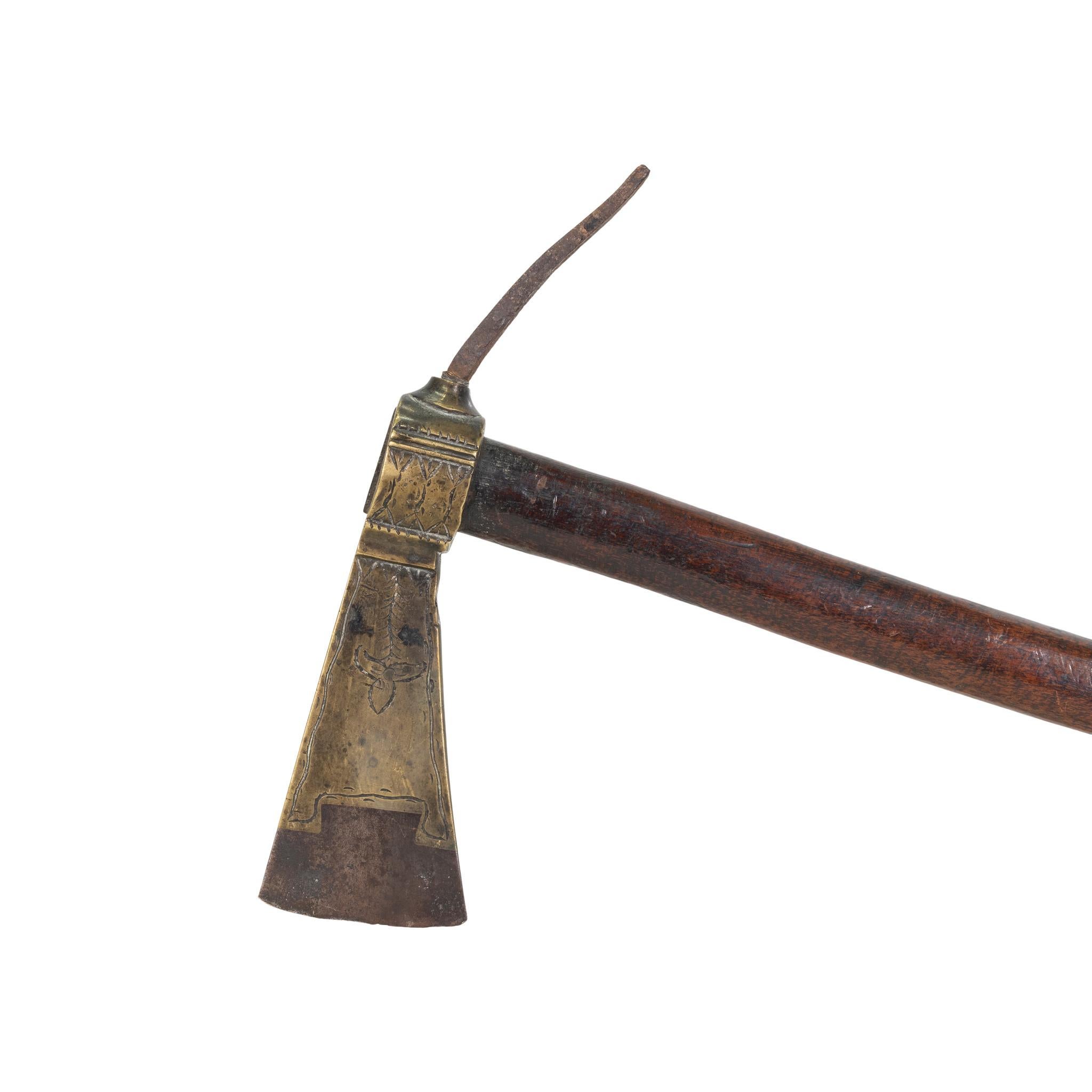 Pipe tomahawk with steel spike inserted into a brass body. Heavily engraved, bowl removed during period of use and steel spike inserted. Shaft was period replaced to non-smoking common to the period in the early 19th Century. This weapon shows an