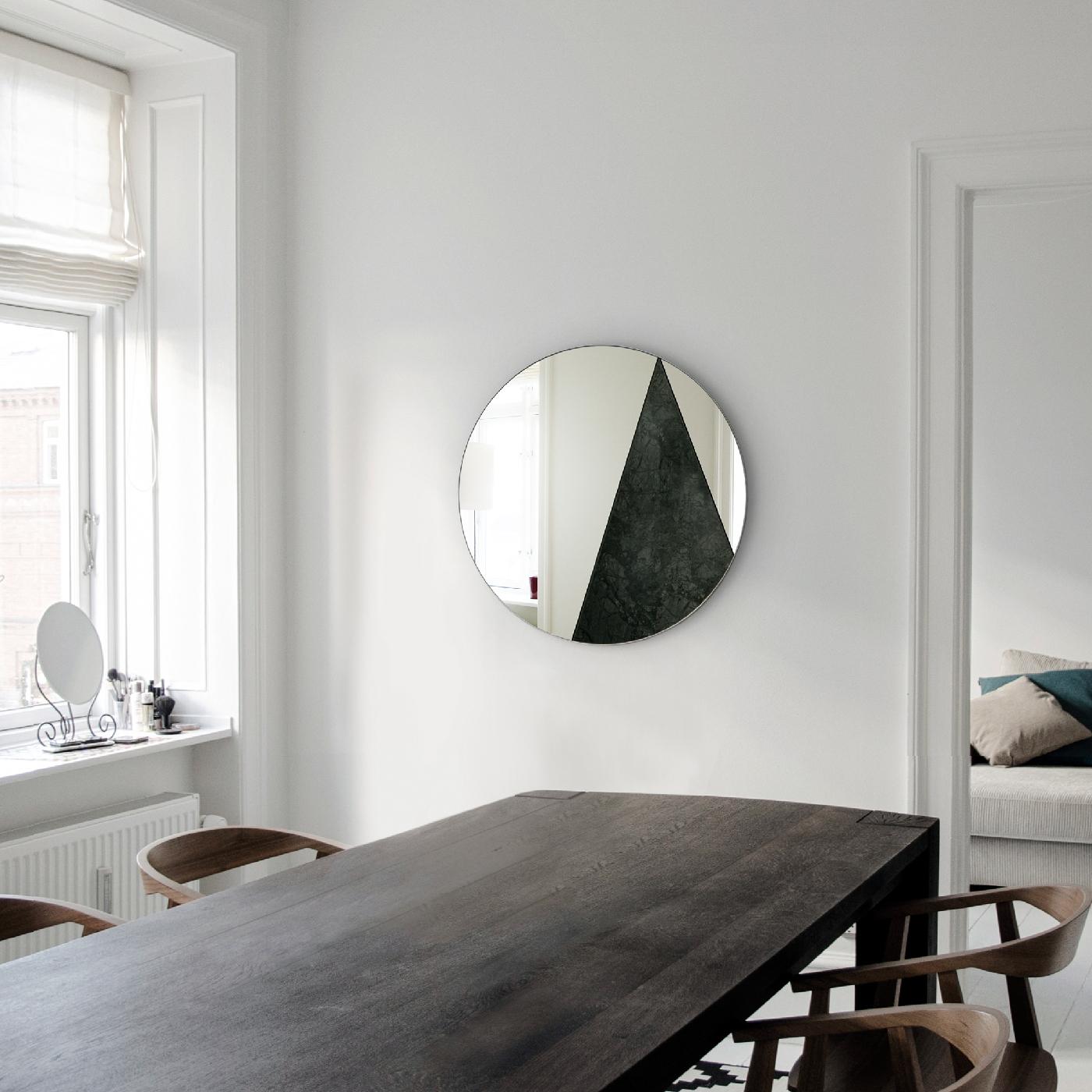 Merging traditional materials with a Minimalist design, the Res collection is a series of handmade mirrors of strong visual impact marked by an exquisite manufacturing quality. This mirror's round silhouette rests on a wooden base and comprises two