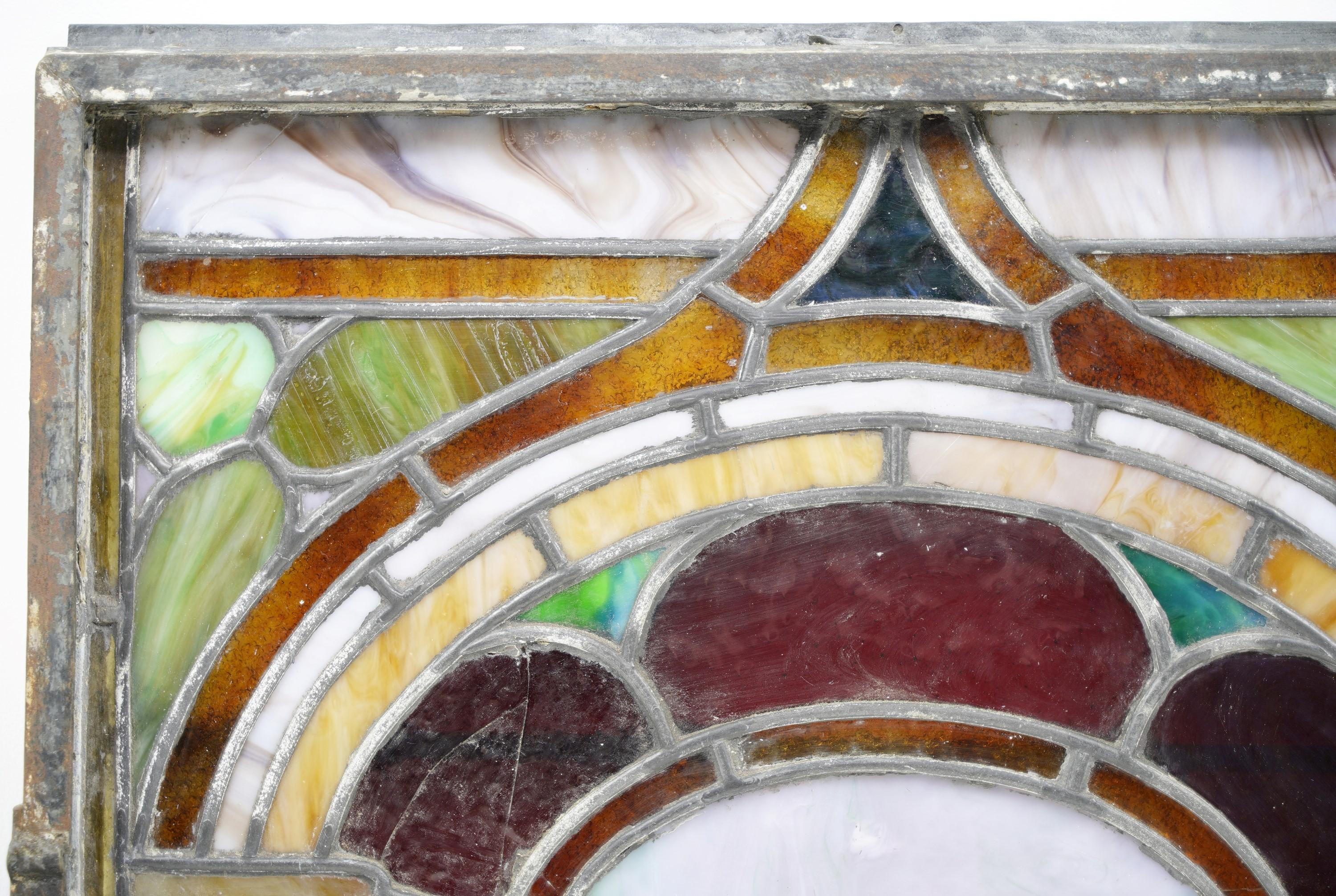 Early 20th Century colorful stained glass window featuring an arched design. Please note, this has three cracks. Please see images. Please note, this item is located in our Scranton, PA location.
