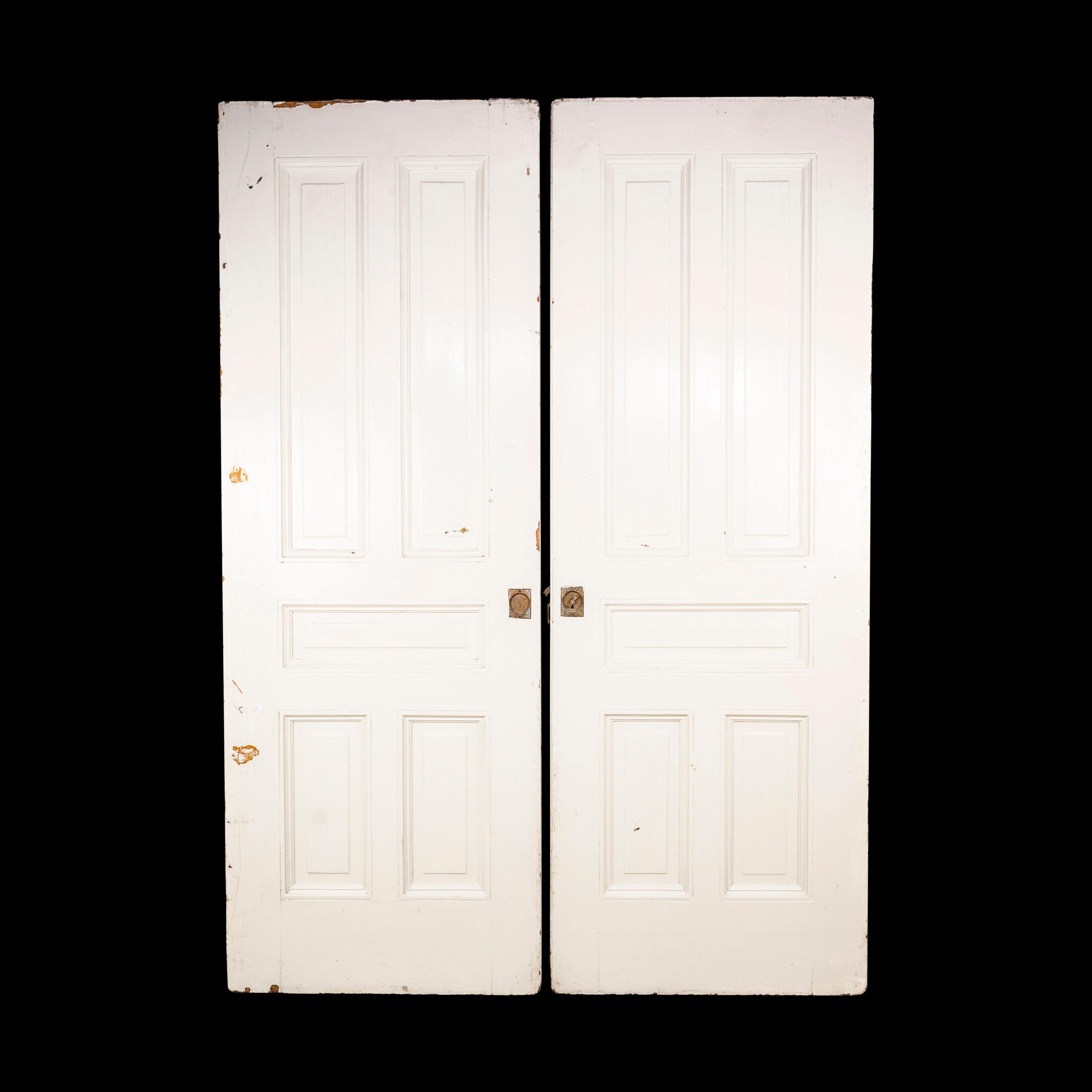 Early 20th Century pair of wood sliding pocket doors with five panels each. Cchipped corners and scratches in the white paint. Comes with some of the original hardware. Please see photos. The bottom wheels still slide. Priced as a pair. Please note,