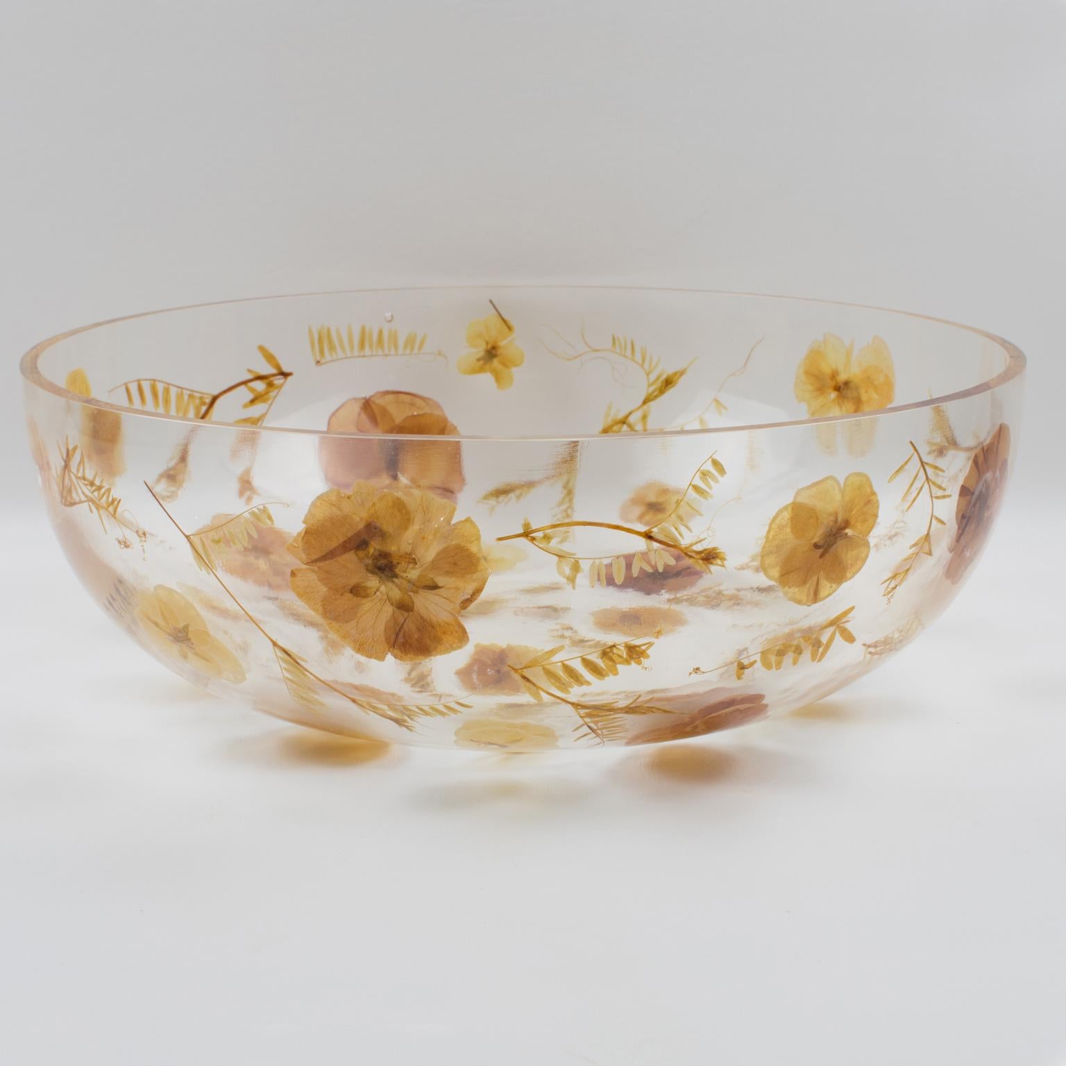 1970s resin decorative bowl, centerpiece, or serving dish by Resinplast, Italy. Extra thick clear resin or acrylic deep rounded oversized bowl shape with assorted real autumn leaves and dried flowers embedded in the material. The natural light