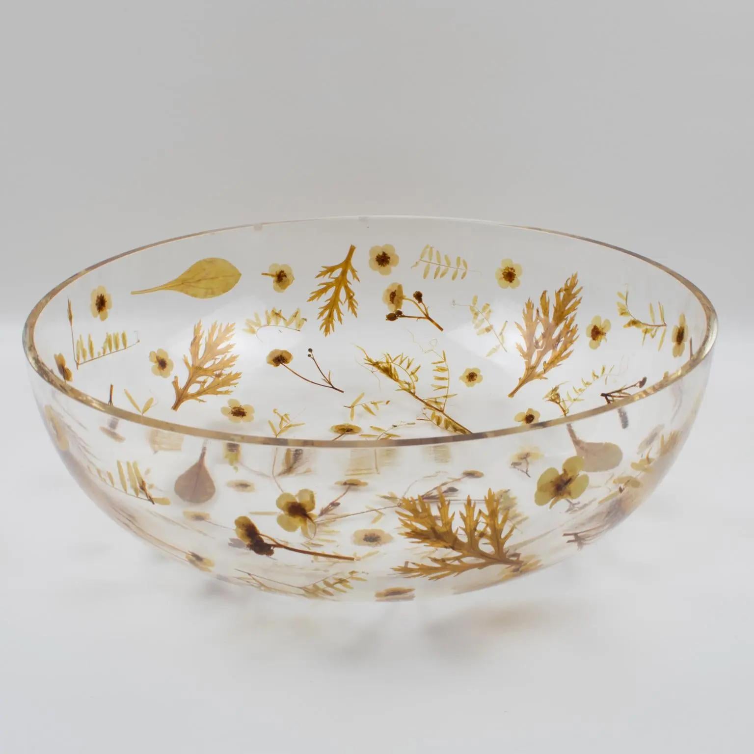 This lovely Resin decorative bowl, centerpiece, or serving dish was designed by Resinplast, Italy, in the 1970s. The extra thick clear resin or acrylic deep rounded oversized shape has assorted autumn leaves and dried flowers embedded in the