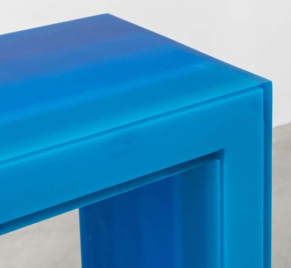 Cette console bleue est fabriquée en résine et présente un effet d'ombre, les couleurs passant du sombre au clair sur la surface. L'effet de profondeur créé oblige l'observateur à déplacer constamment son regard le long de la courbe de saturation,