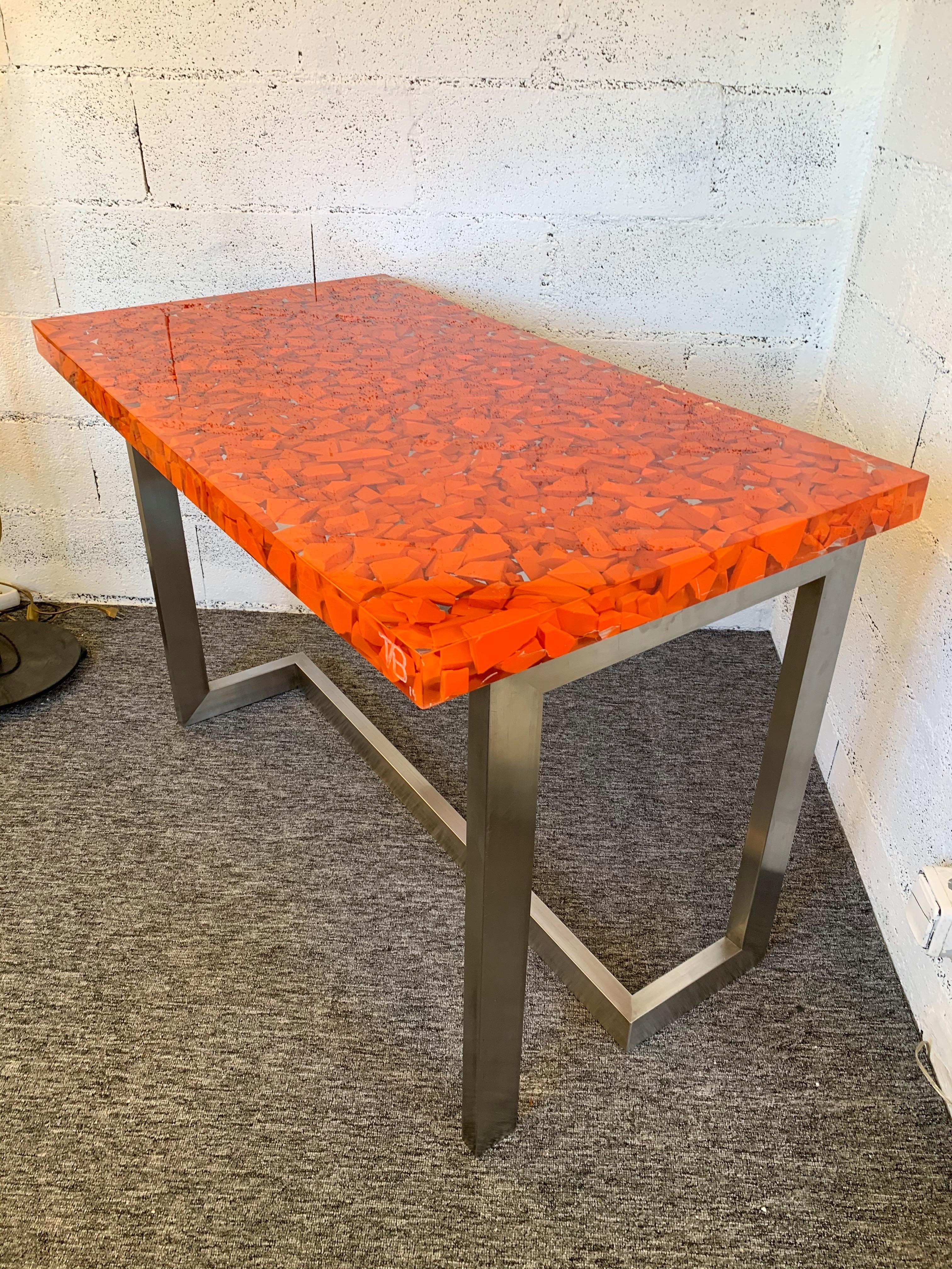 Table console ou bureau en résine massive orange inclusion, beaux pieds en acier inoxydable par l'artiste Thomas Brant. Monogramme TB et date 2014. Edition de 10 exemplaires. Un travail différent de la résine fractale de Pierre Giraudon, François