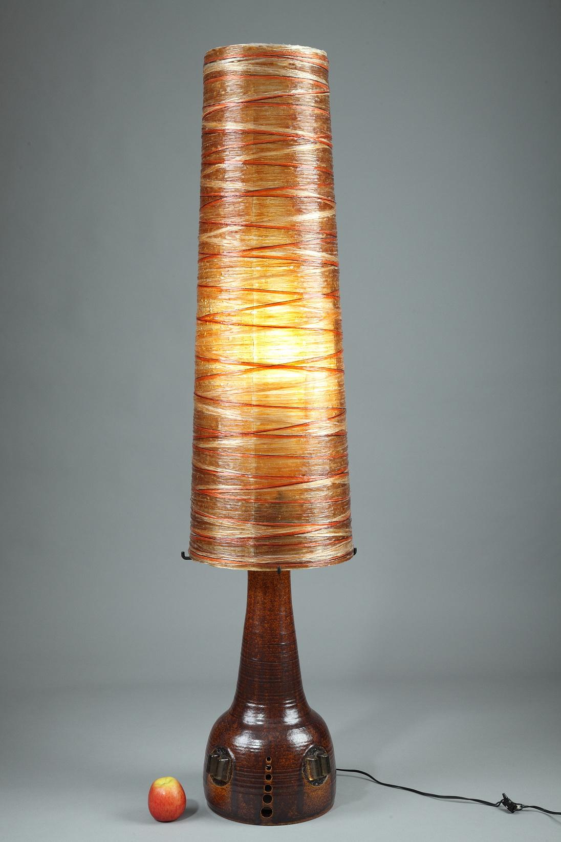 Grande lampe des ateliers Accolay composée d'une base en céramique patinée et d'un abat-jour conique en corde et en résine orange et noire. Cette belle lampe orange des années 1970 possède deux ampoules, l'une au centre de l'abat-jour et l'autre