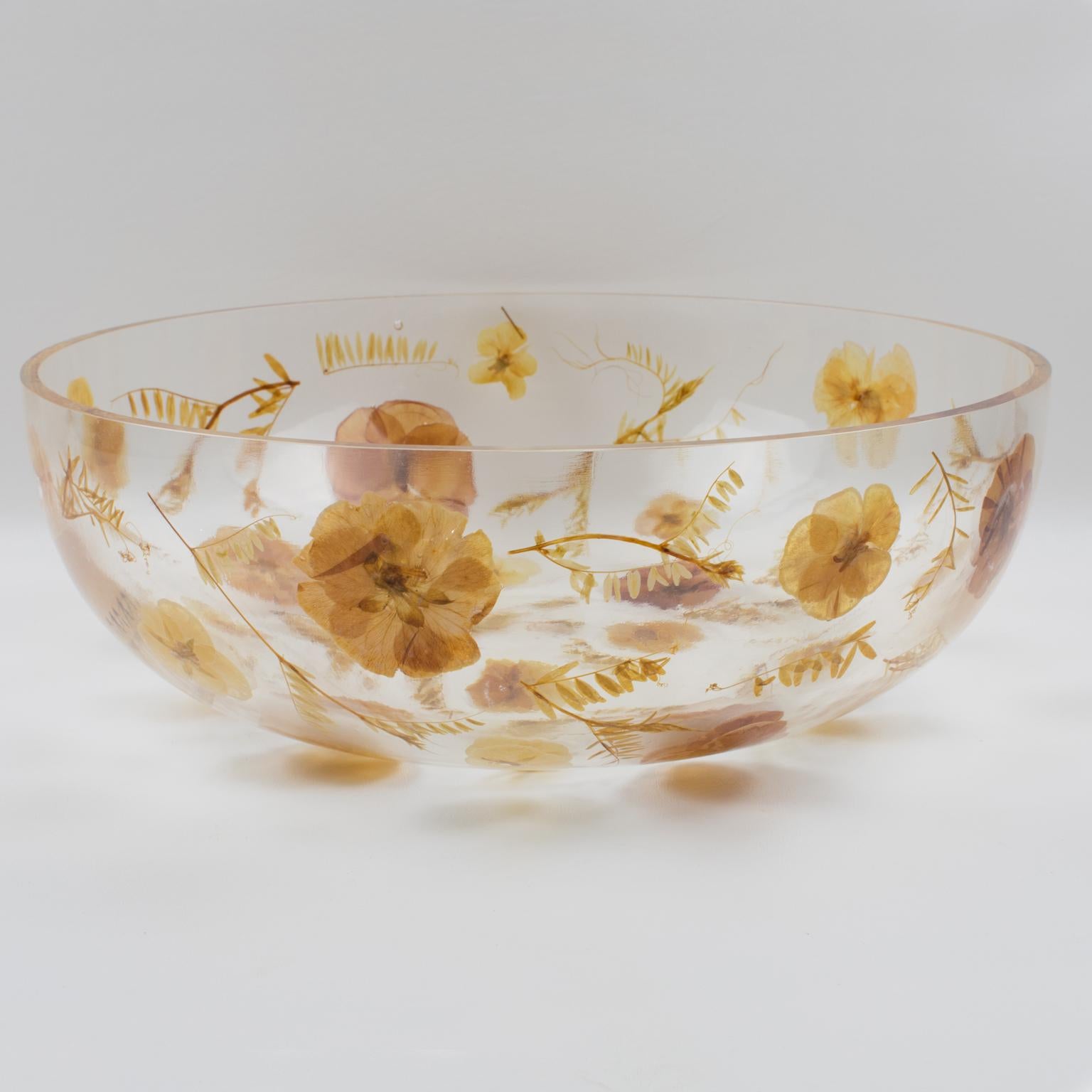 Resinplast, Italy, manufactured this stunning resin decorative bowl, centerpiece, or serving dish in the 1970s. The extra-thick, clear resin or acrylic, deep, rounded, oversized bowl shape has assorted genuine autumn leaves and dried flowers