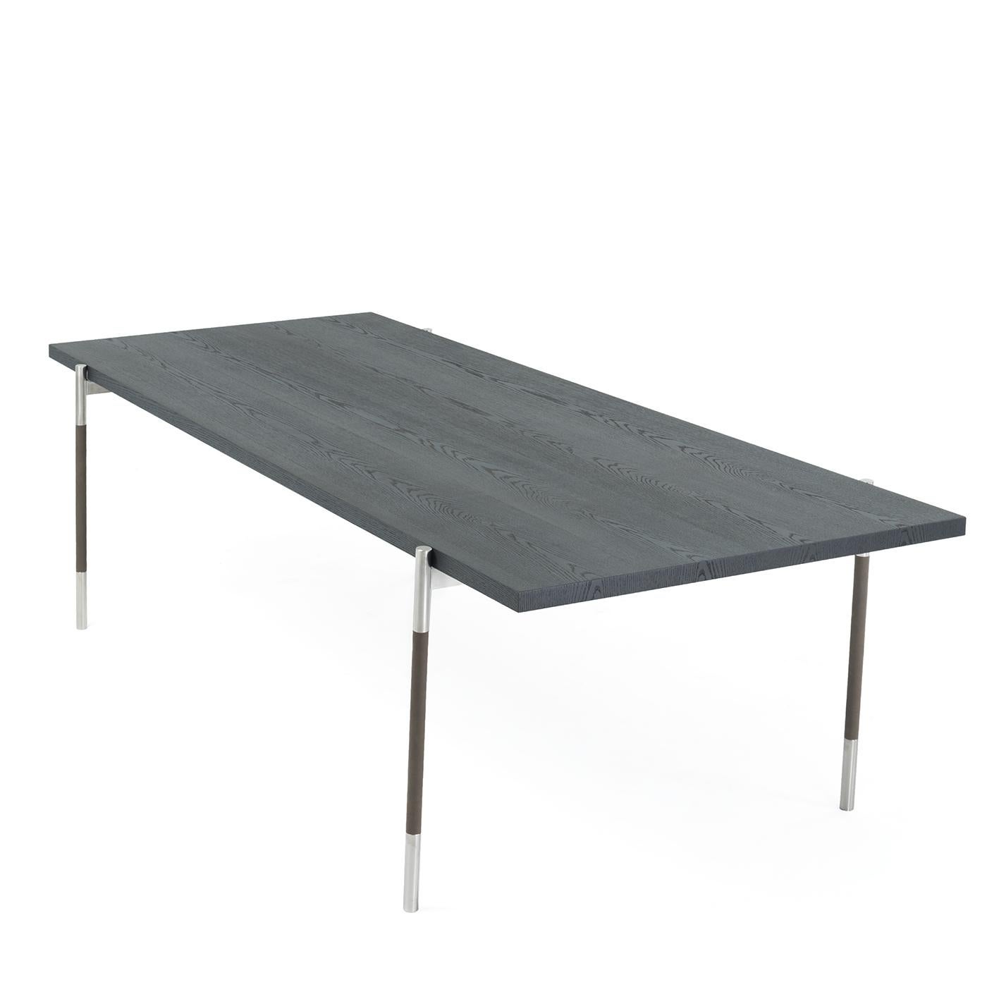 This barely there oak table seems to defy gravity. It’s thin, brushed charcoal gray top floats over four narrow satin stainless steel legs with genuine leather detailing. It comfortably seats eight people, making it the perfect addition to a dining
