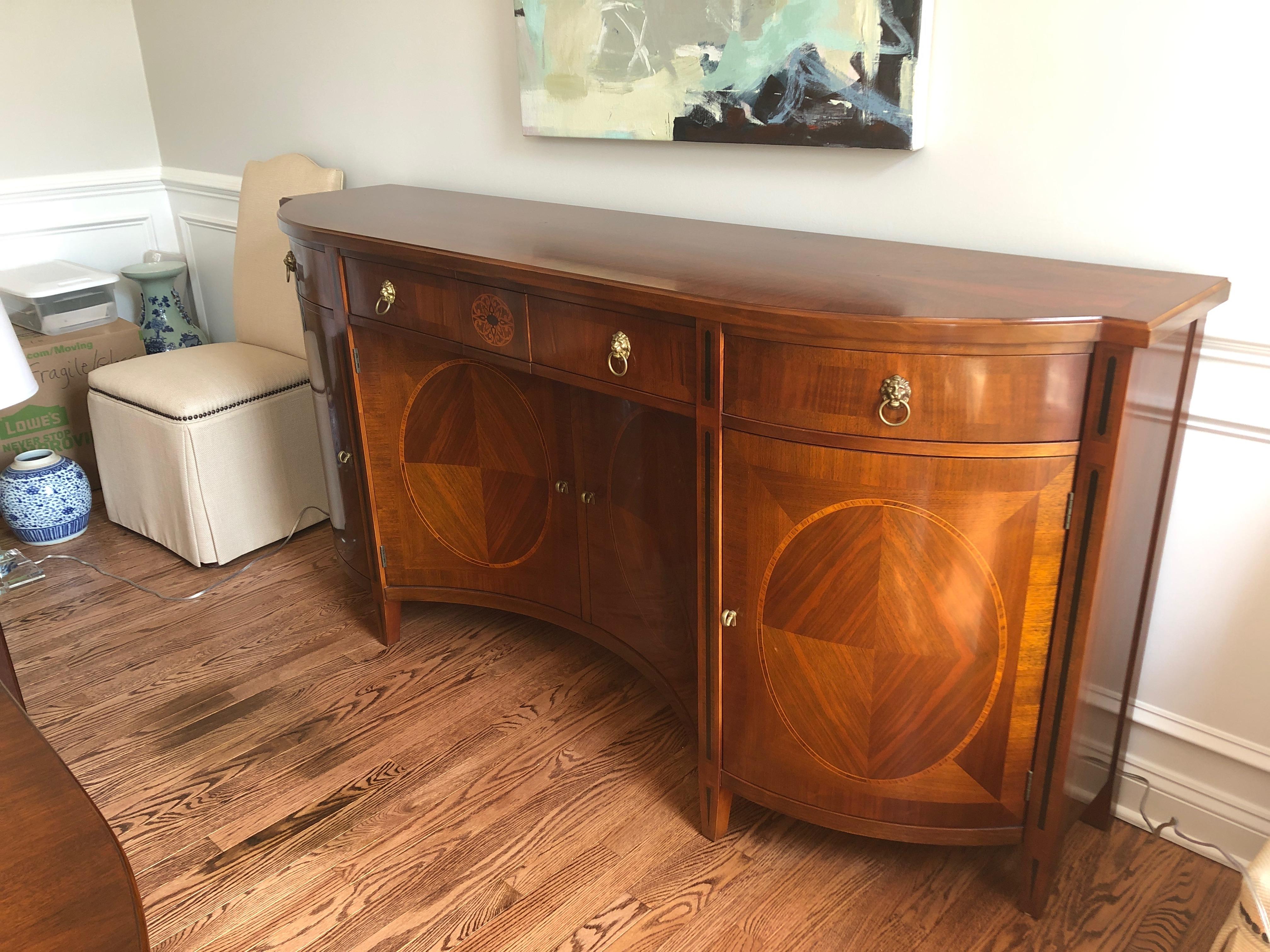 A Russian style very large fancy credenza having mahogany and fruitwood inlay by John Widdicomb. A fine example of a neoclassical Russian sideboard that features Greco Roman lion mask drawer pulls and an elaborate inlaid decoration including