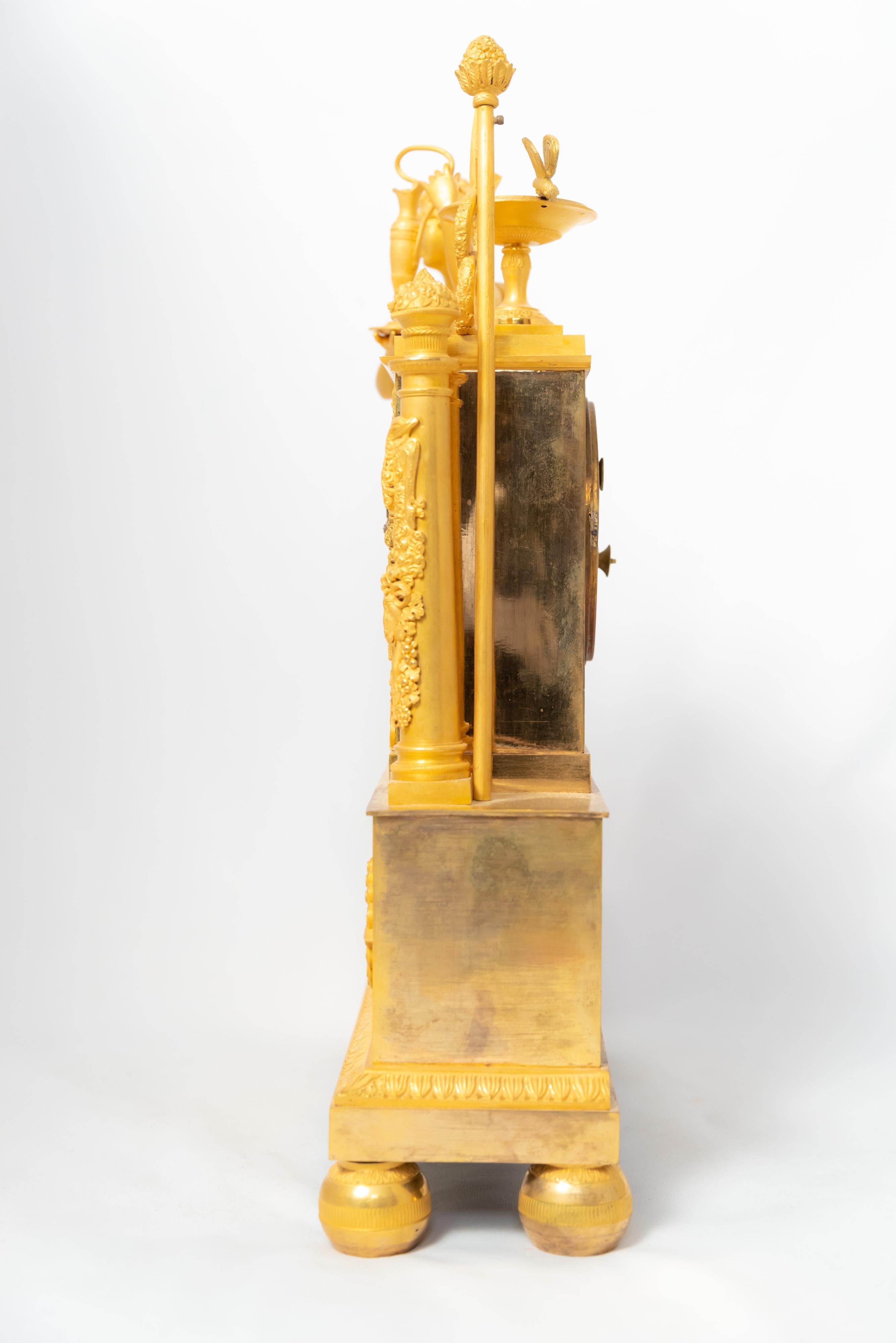 Eine Kaminsimsuhr aus der französischen Restaurationszeit von 1815-1830 aus feuervergoldeter Bronze. Das Zifferblatt ist weiß emailliert und die Stunden sind mit römischen Ziffern dargestellt. Die Figur stellt die Göttin Hera, die Frau des Zeus,