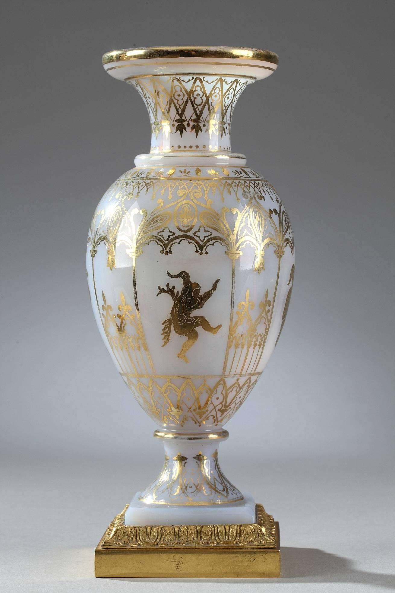 Pair of white opaline glass vases decorated with gilded Gothic arcades and medieval figures playing music or dancing. Each vase rests on a square gilt bronze base embellished with foliage. This delicate decoration was produced by the Jean-Baptiste