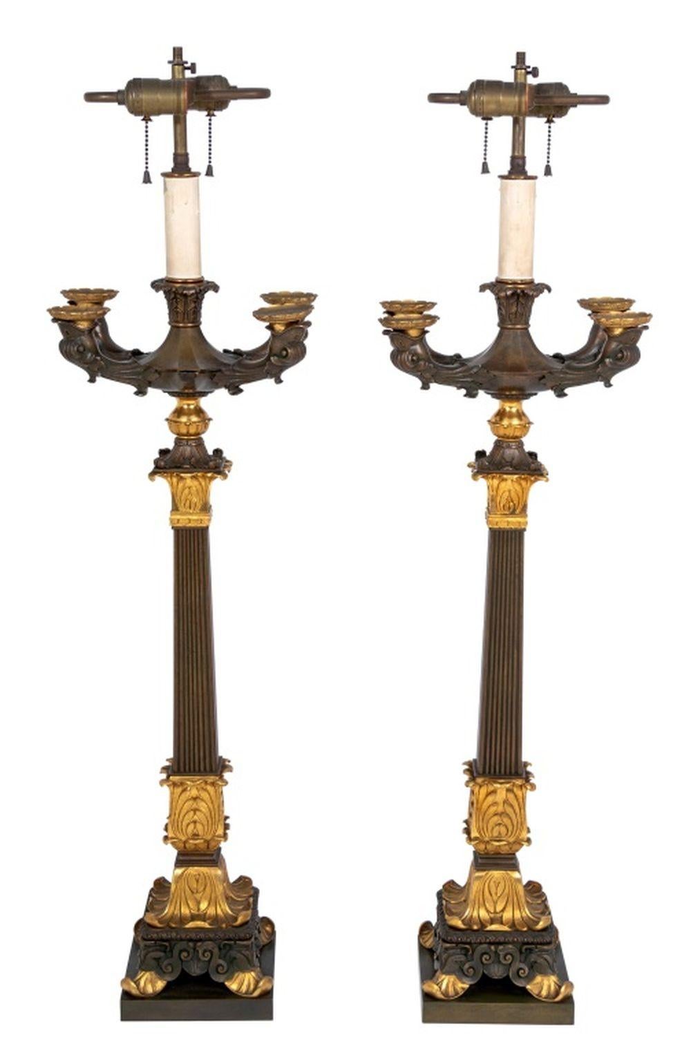Coppia di candelabri in bronzo e ormolù di Restauro, 1830 circa, ciascuno con cinque rami su colonne affusolate a foglie di canna e basi conformi. 38,5