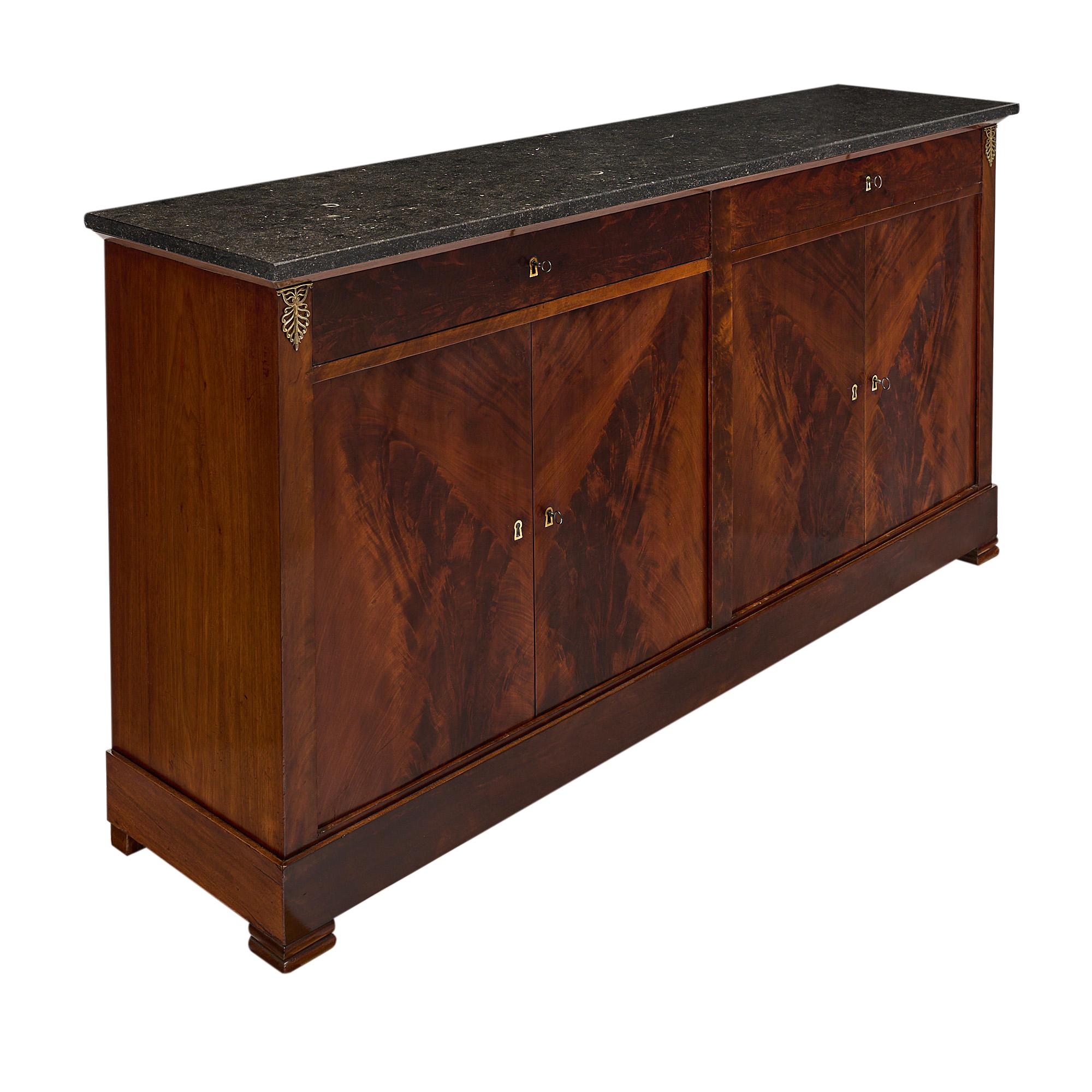 Buffet, enfilade, French, from the Restauration period. This piece is made of Cuban flamed mahogany. There are two dovetailed drawers and four doors that open to adjustable shelves. This period credenza is topped with an intact black marble slab.