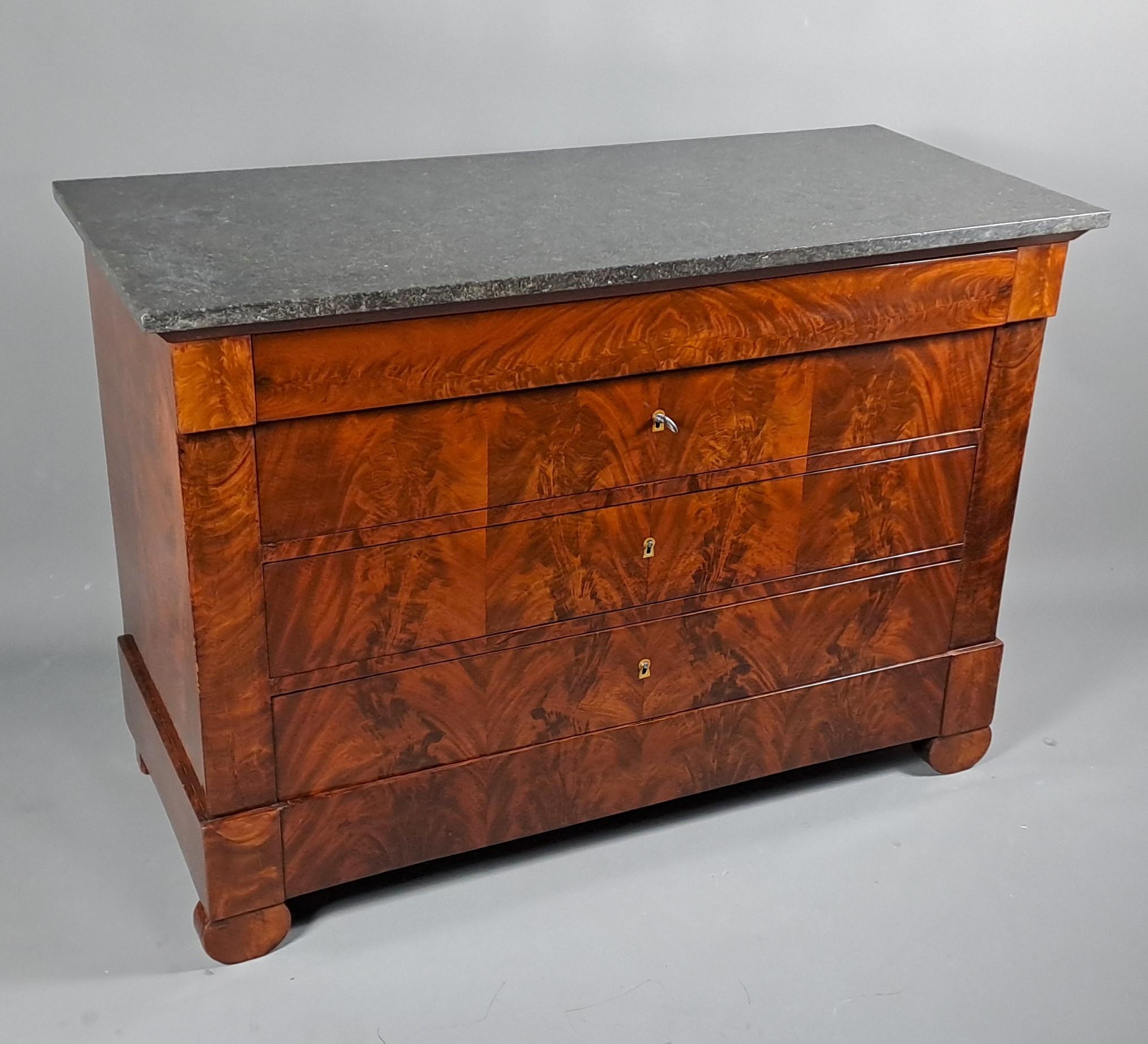 Sublime Restauration Period chest of drawers in flamed mahogany on all sides, topped with black granite marble.

Opening four drawers.

Exceptional facade treated in symmetrical double flame.

Built in solid oak Parisian work around 1820/1830, bears