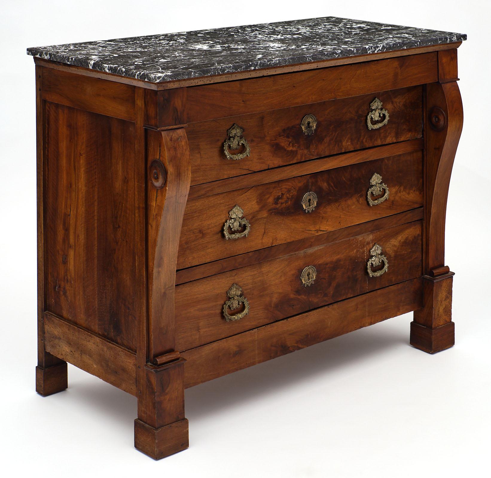 French Restauration period walnut chest of drawers with four dovetailed drawers. A fine French antique piece made of solid figured walnut with all original finely cast bronze hardware. The commode features columns on each side; typical of the