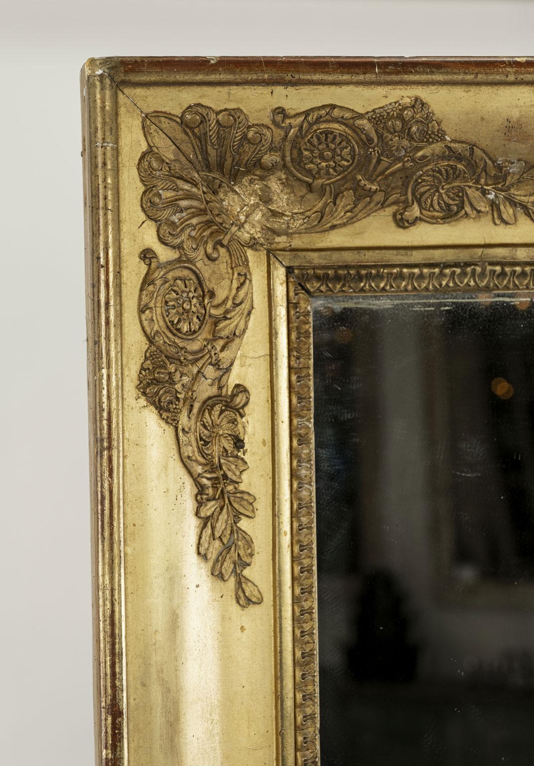Miroir en bois doré d'époque Restauration avec glace au mercure ancienne - ou d'origine - (vers 1815-1830). Petites quantités de poussière de diamant sur les bords.

Note : Les différences régionales d'humidité et de climat pendant le transport