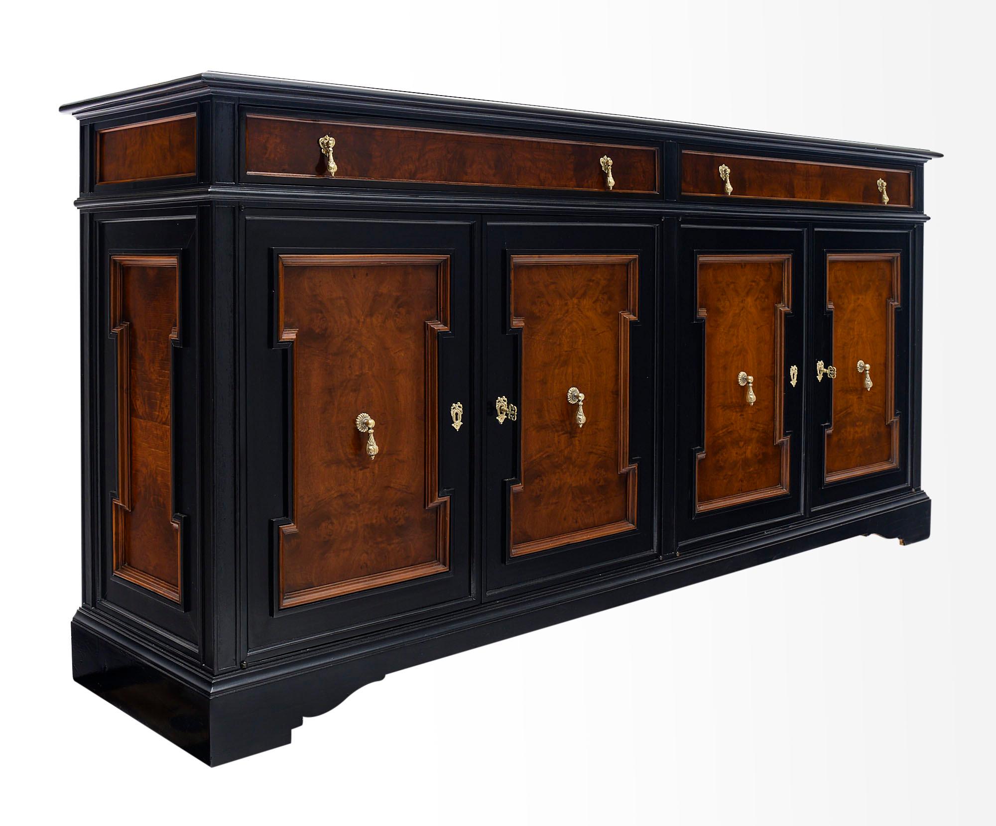 Buffet; French; made of solid ebonized walnut and burled walnut. There are two dovetailed drawers and four doors that open up to interior shelving. The piece boasts finely cast brass hardware and a lustrous French polish.