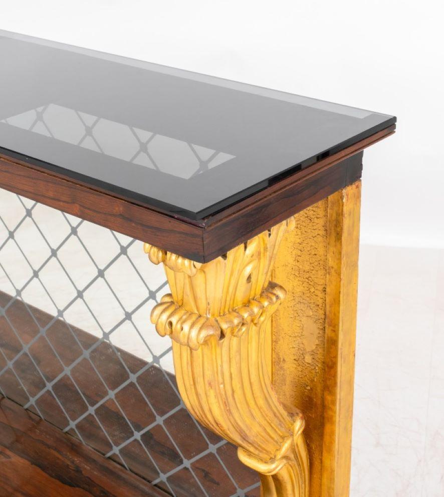 Restauration Style Parcel-Gilt Rosewood Console, likely 1960s or later, the rectangular black smoky glass top above a conforming rosewood frame above a trellised mercury glass back plate between giltwood scrolling volute supports on a plinth base.