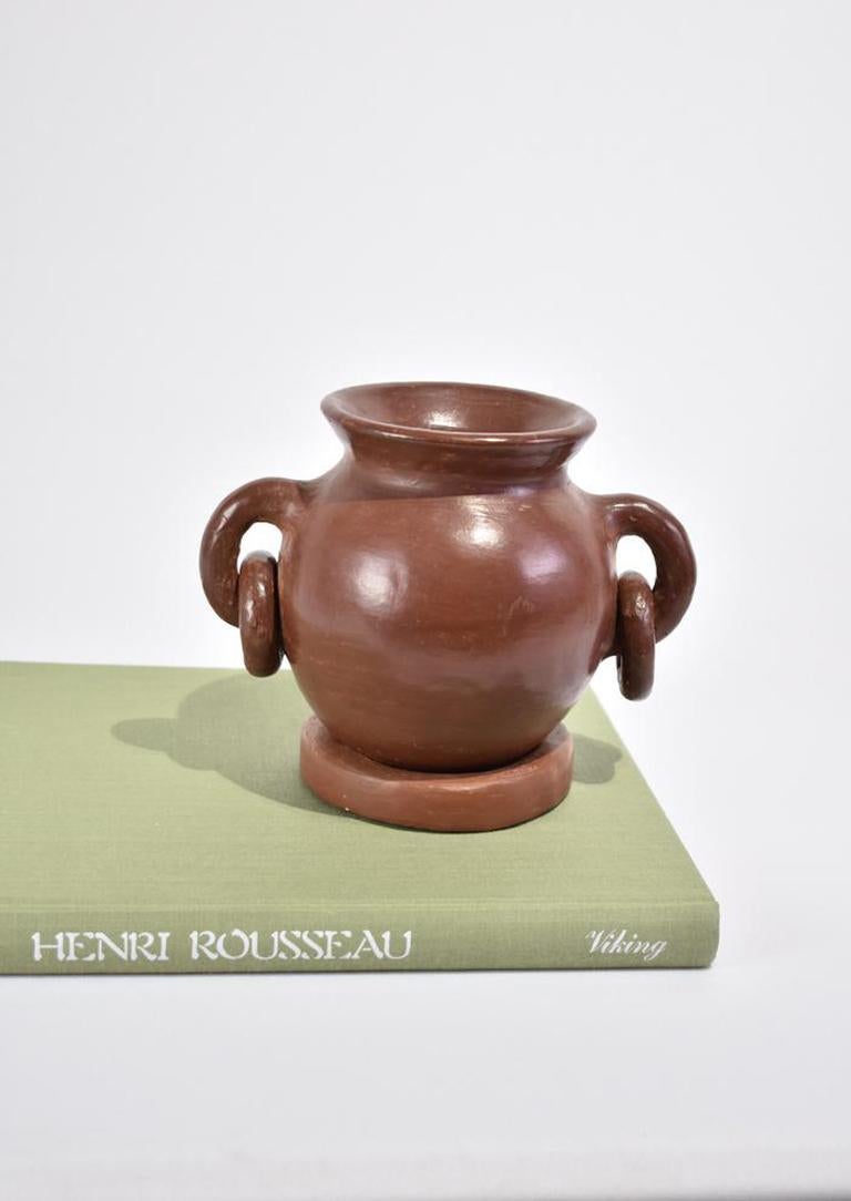 Sculptural handmade terracotta jug with two handles and ring details that rests on a clay ring. One-of-a-kind piece.
 