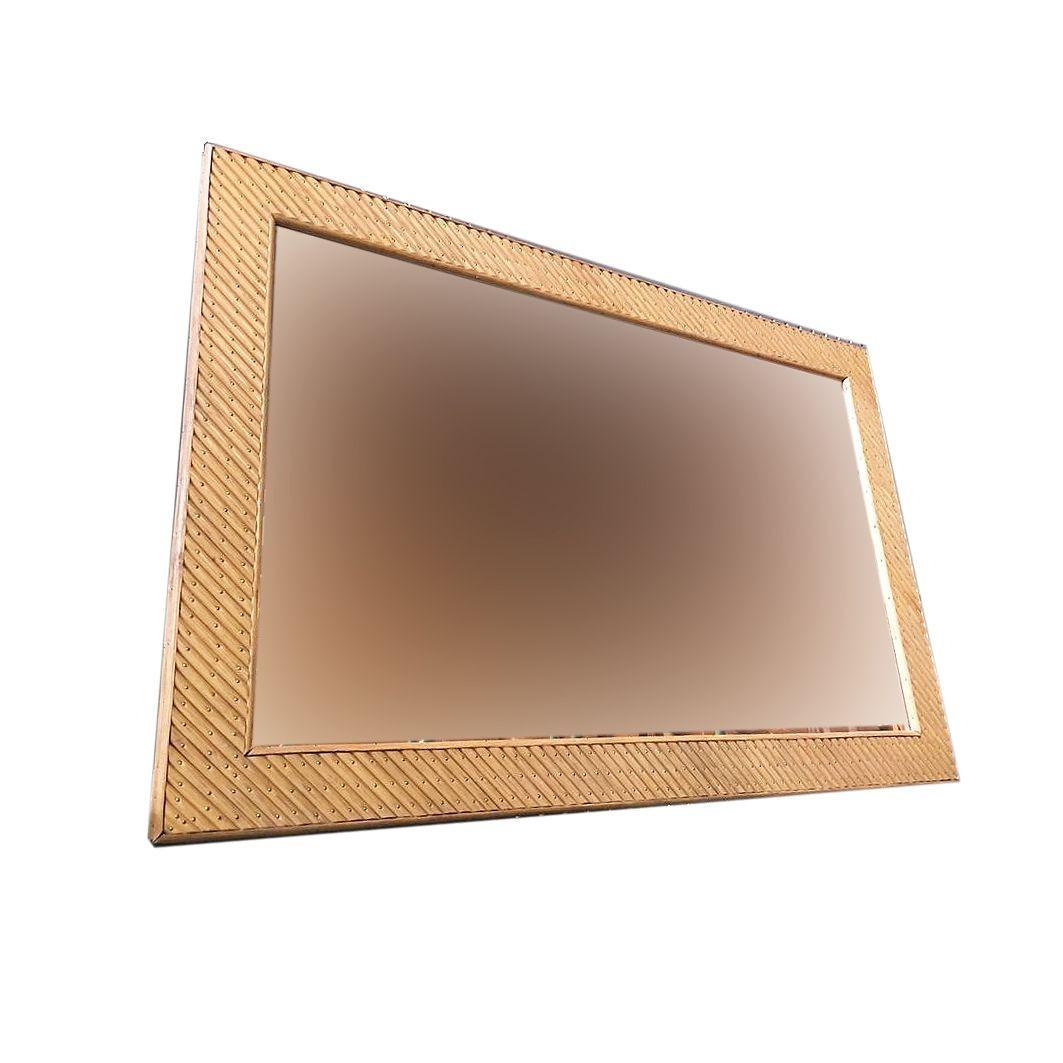 Large rectangular peach glass mirror featuring a slanted cut stick rattan frame with decorative brass nail accents. Restored to new for you.

1950, United States

We only purchase and sell only the best and finest rattan furniture made by the
