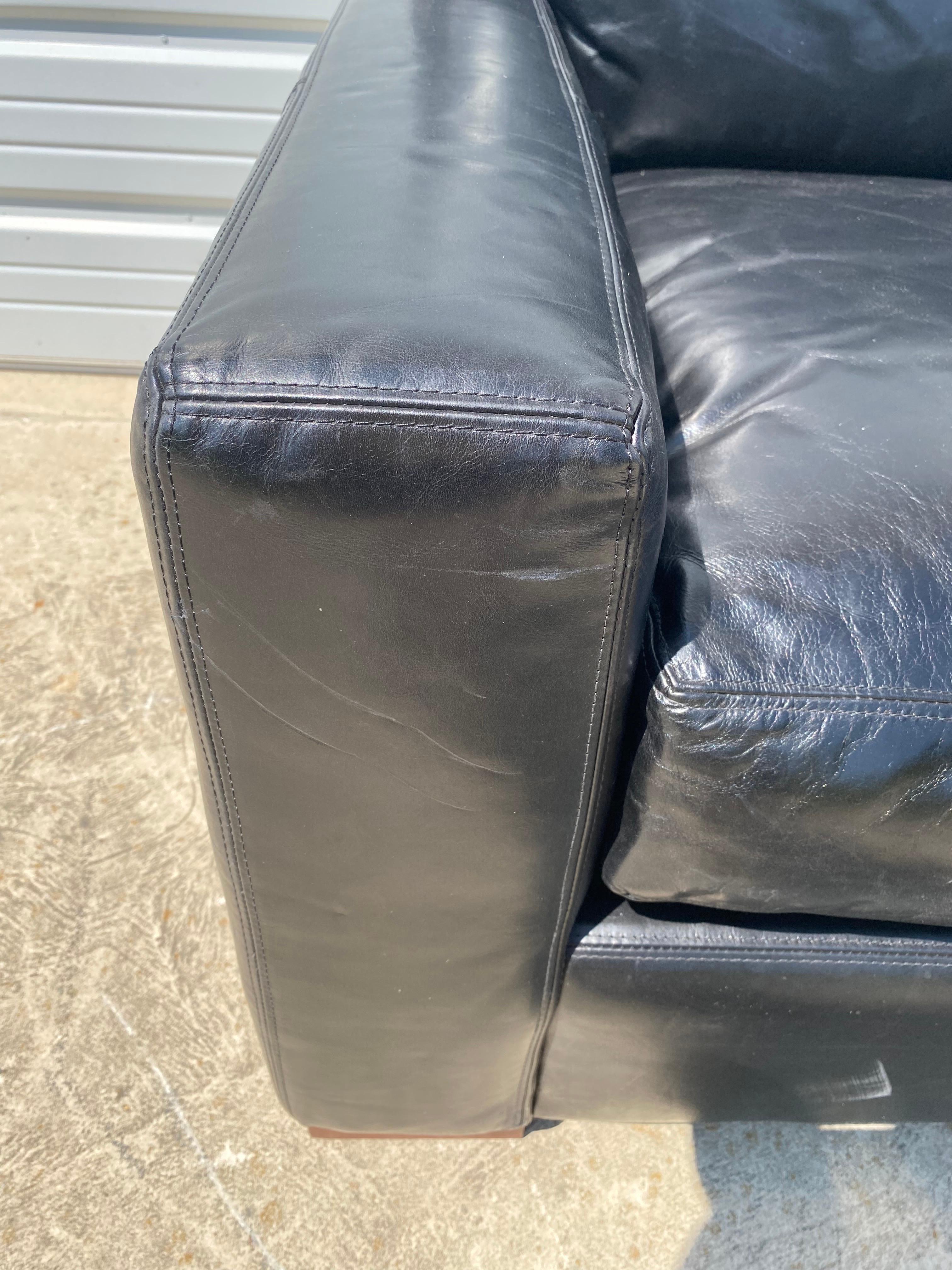 This is a Restoration Hardware black leather club chair. This plush black leather chair has a masculine deco Clubhouse style. The chair has an antique crackle finish to the leather made by Restoration Hardware circa 1990.
