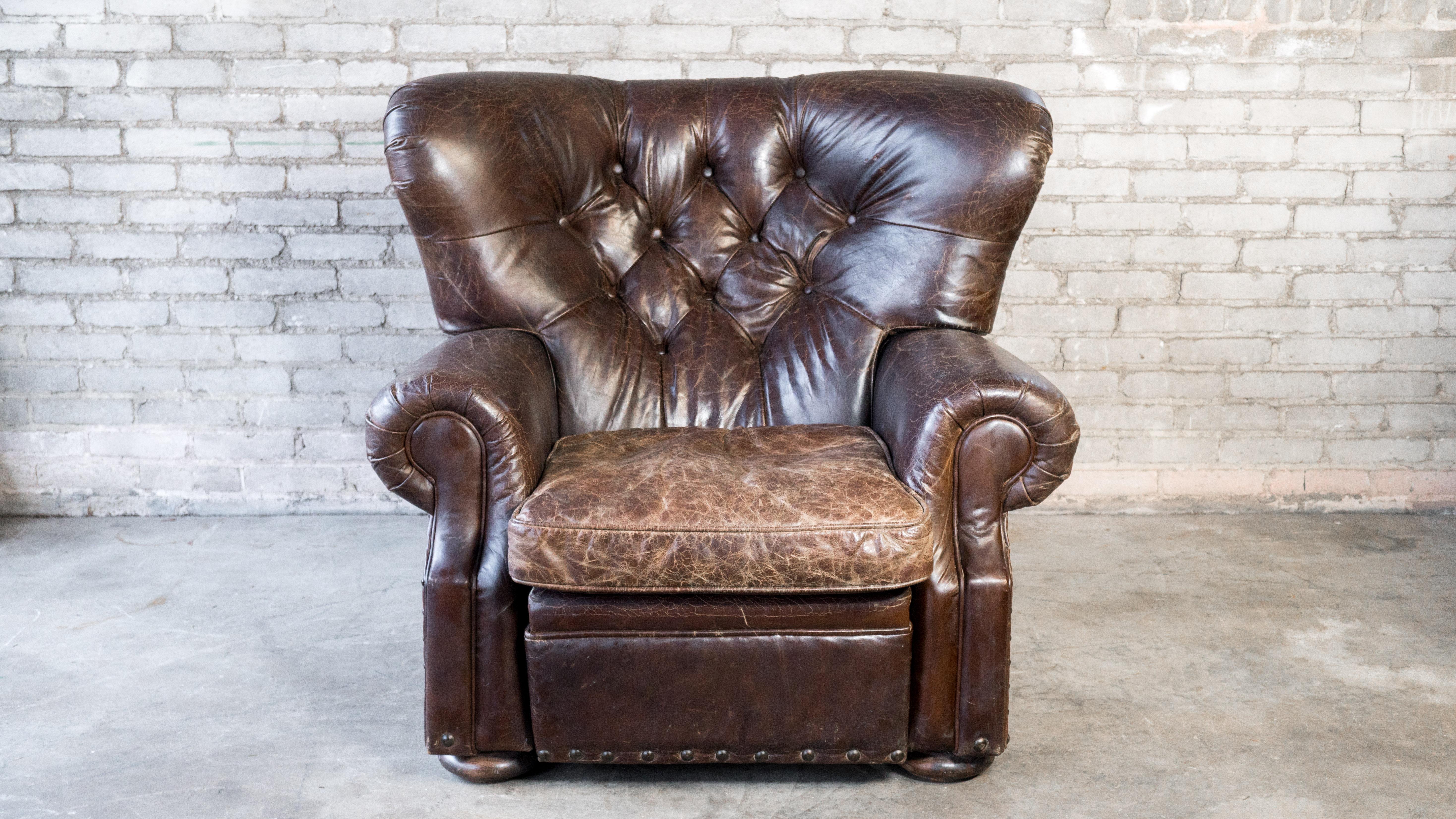 Restoration Hardware 'Churchill' recliner writer's chair, in a lovely dark brown with nice distressed patina. Thick supple leather with tufted backrest and brass nailhead trim. Timeless English Traditional design. Supportive cushion, immersive