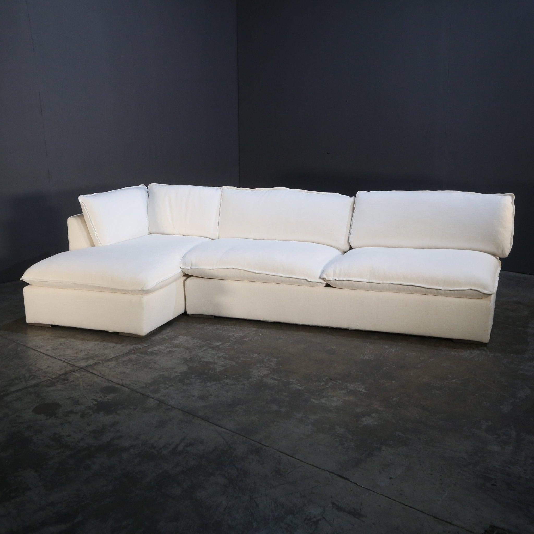 Introducing the Costera Sectional Sofa by Restoration Hardware, a luxurious centerpiece for any living space. This cream-colored sectional features a minimalist yet inviting design, with generously padded cushions that promise exceptional comfort.