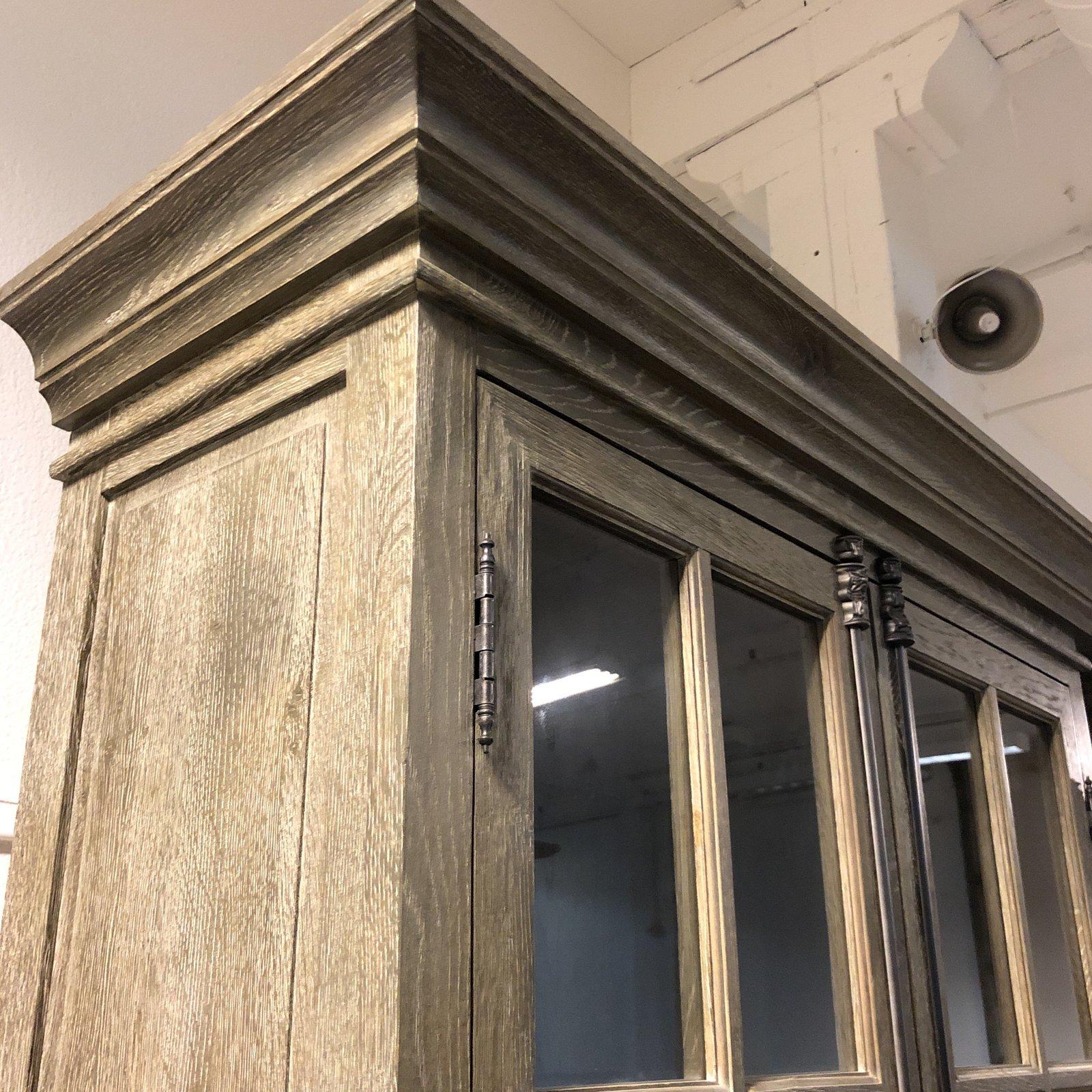 A French Casement double-door cabinet by Restoration Hardware. Designed by Luay Al-Rawi, whom was inspired by the Classic French furniture. Constructed of solid wood with two glass paneled doors. cast iron cremone hardware, a signature element of