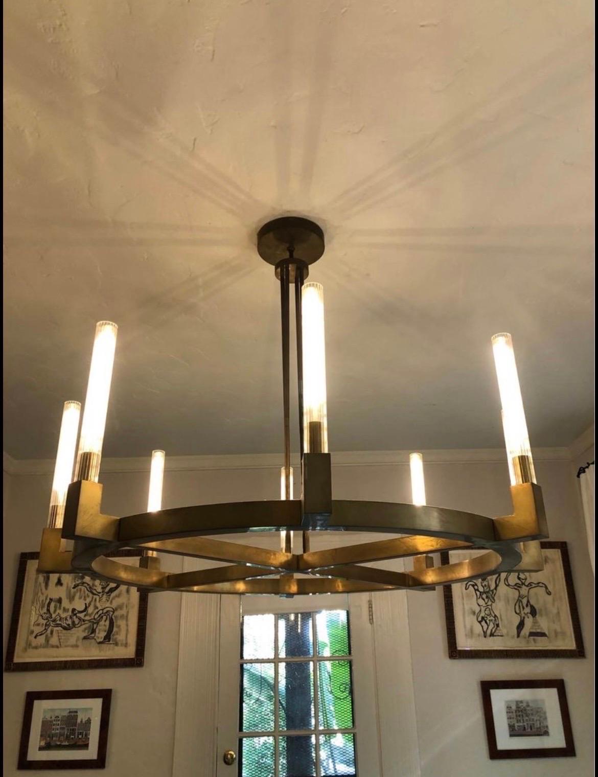 Restoration Hardware Cannele round chandelier 

“The form of a Beaux Arts chandeleir is interpreted in solid brass by renowned lighting designer Jonathan Browning. Defined by clean lines and sharp angles. Includes rubbed glass hurricanes.