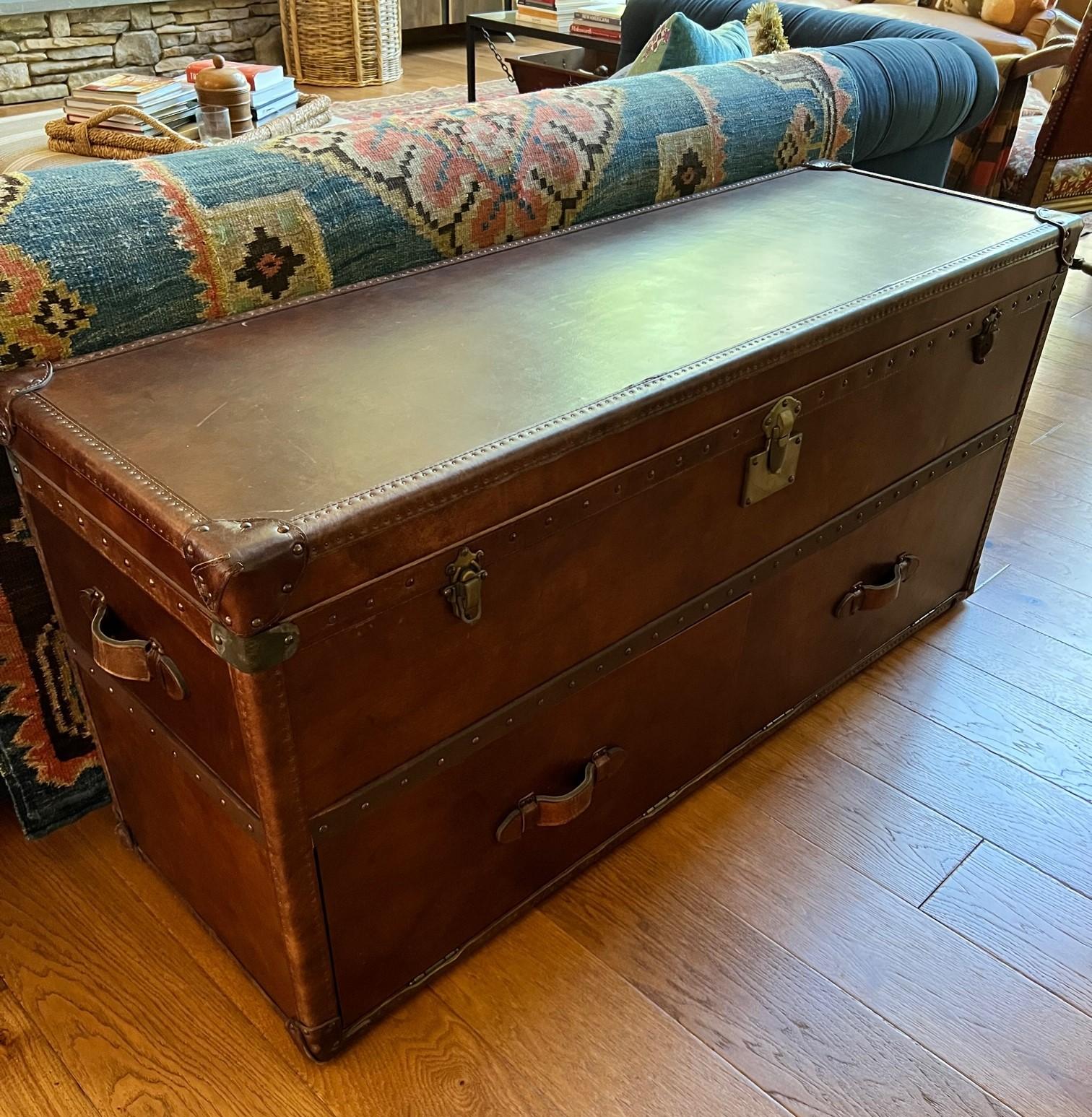 Created for Restoration Hardware by London antiques dealer Timothy Oulton, this media console is made of wood, covered with distressed leather and finished with thousands of hand-hammered nailheads. 

This reproduction antique steamer trunk is
