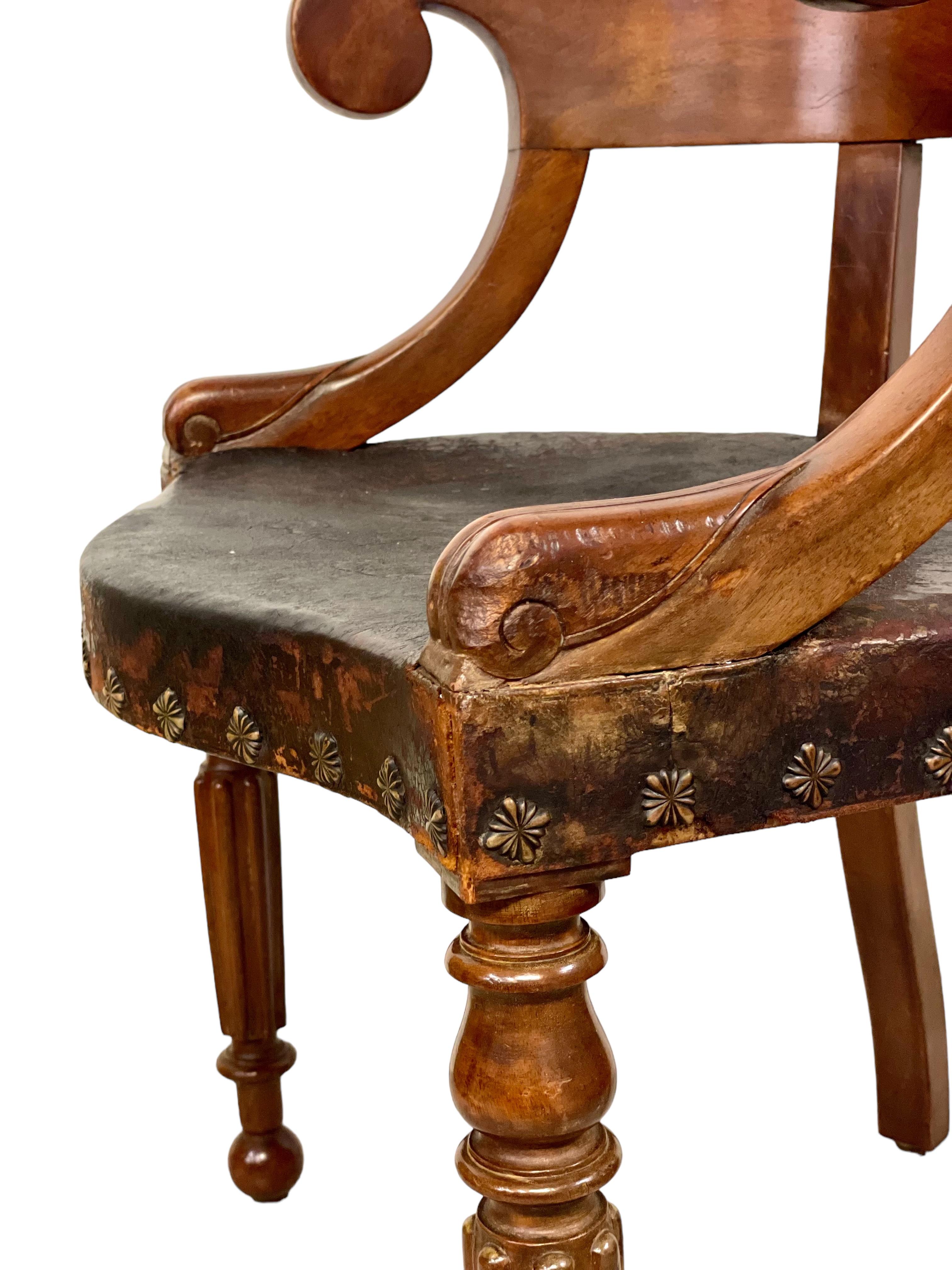A fine French Restoration period barrel-back desk chair (or captain's chair), with dramatically reeded and turned legs, scroll arms and incurved top rail, which is polished smooth for extra comfort. The wide seat has been upholstered with dark brown