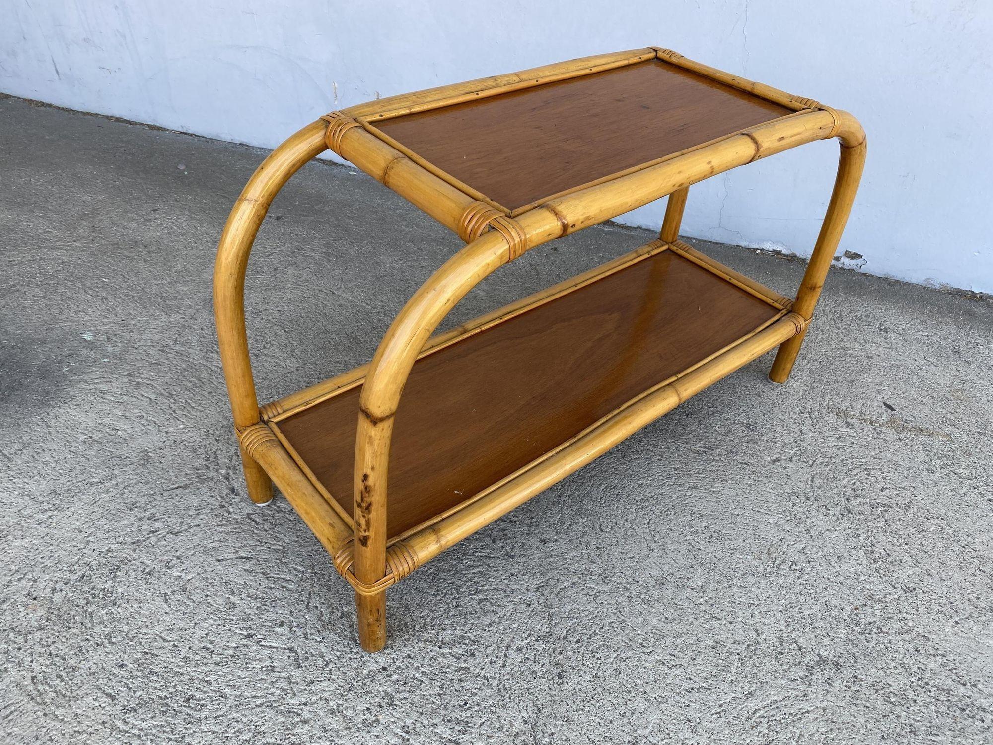 Midcentury single-strand two-tier rattan side table with mahogany tops. The table features wicker-wrapped accents with unique bent-pressed arch legs.

We only purchase and sell the best and finest rattan furniture made by the best and most