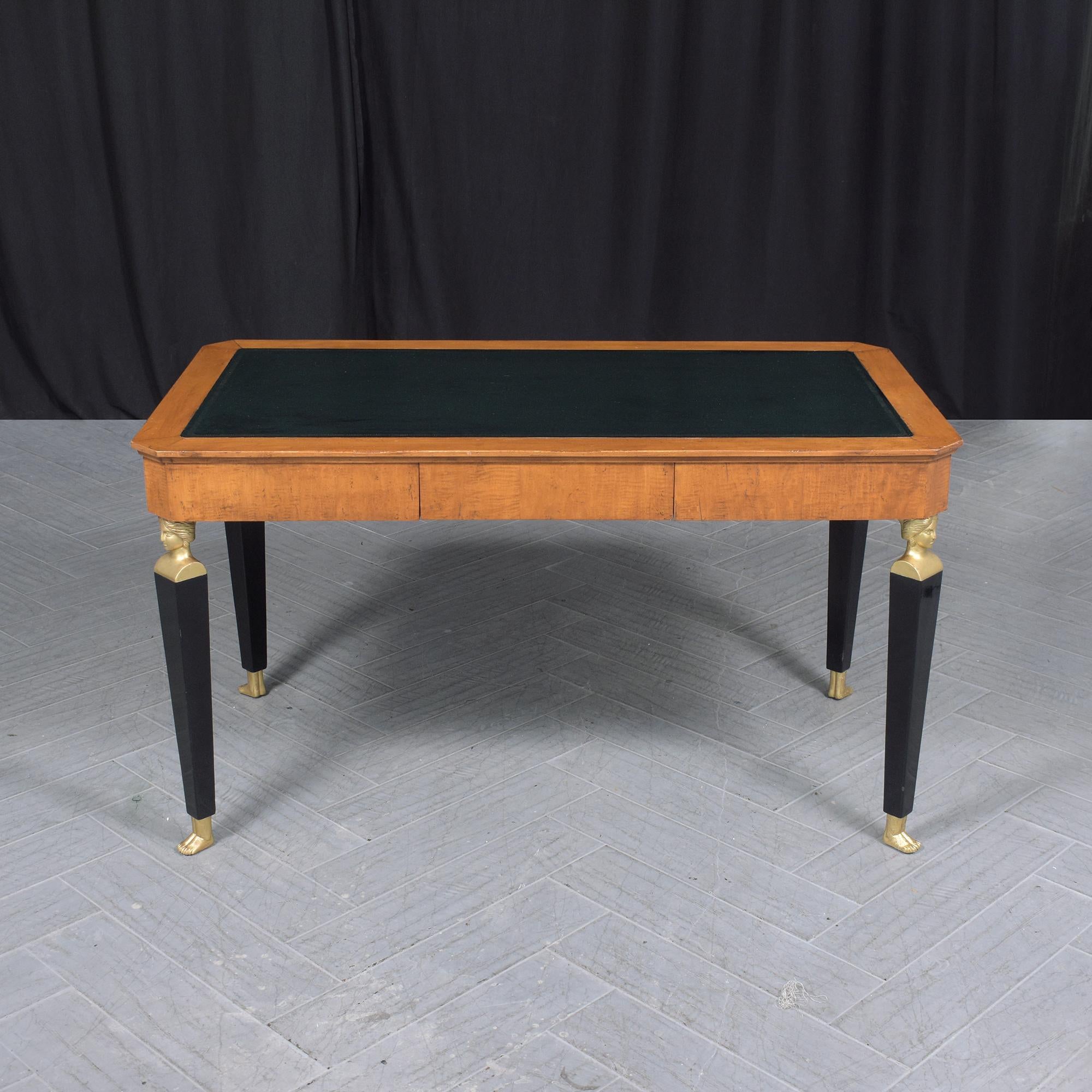 Discover the elegance of this vintage Empire desk, meticulously hand-crafted from wood and professionally restored by our in-house team. In great condition, the desk boasts a rectangular top, adorned with a newly dyed dark green leather insert that